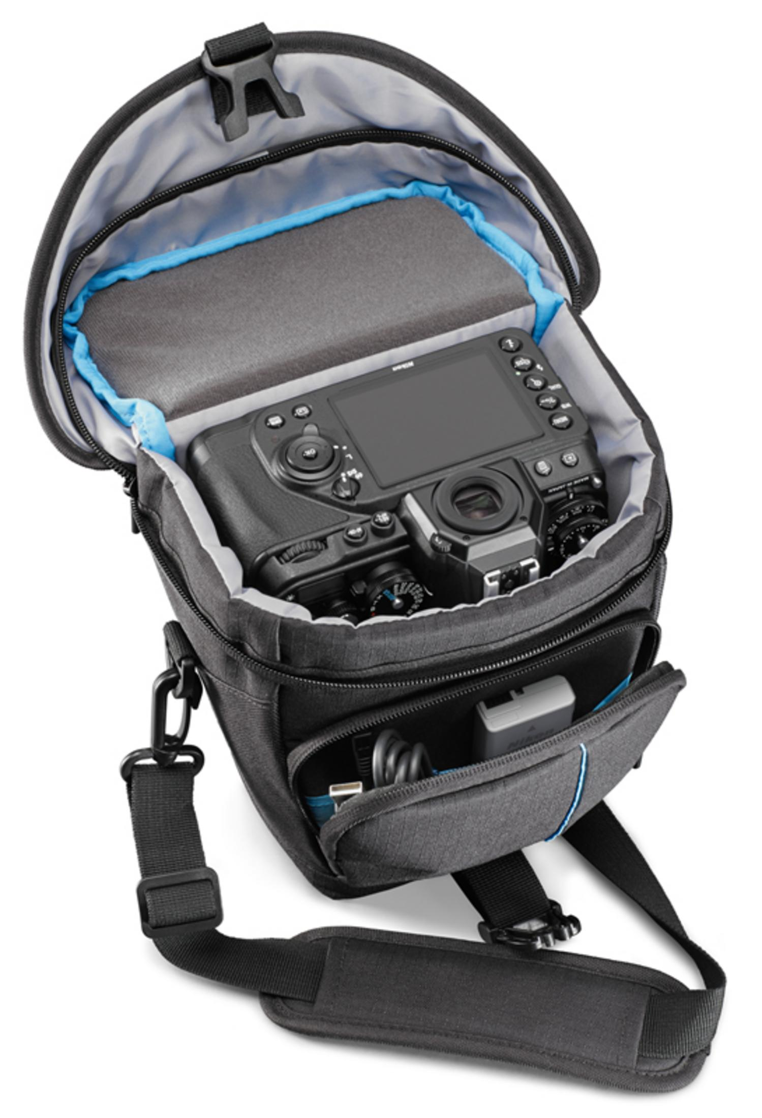 Schwarze Kamera in grauer Tasche. Die Tasche ist offen. Riemen und kleine Tasche sichtbar.