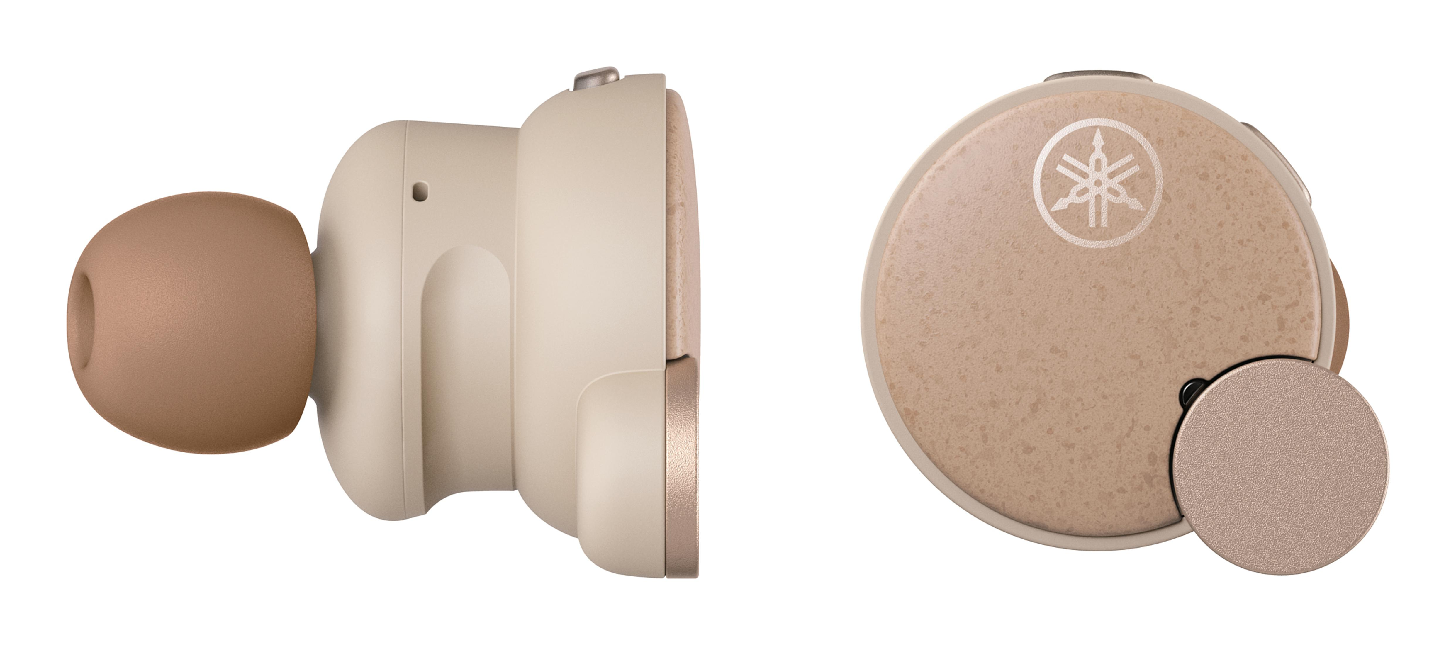 Dwa beżowe słuchawki, jeden z boku, a drugi z logo i osłoną portu ładowania.