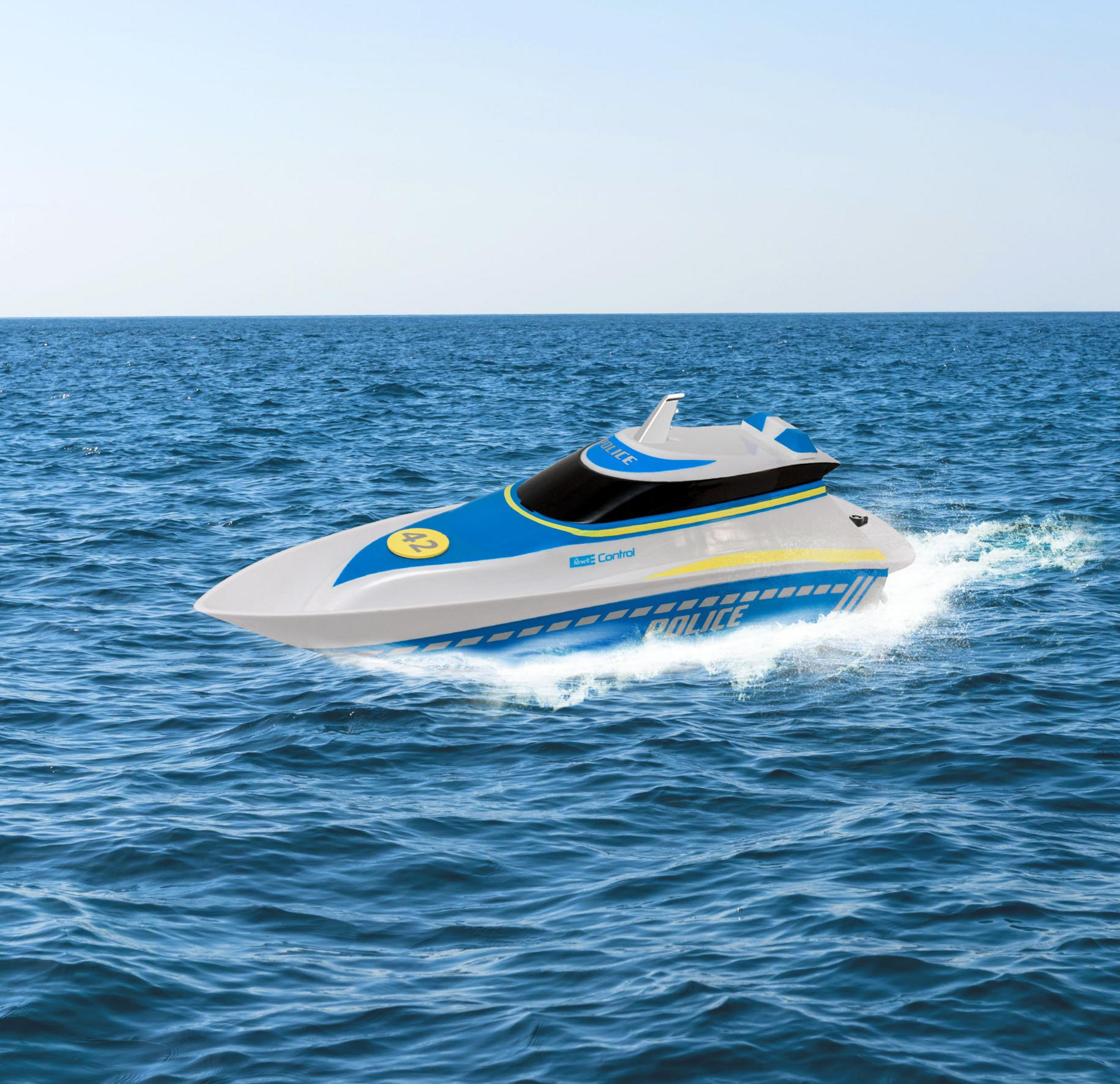 Ein weißes und blaues Spielzeugboot auf dem Wasser. Das Boot hat ein Polizeilogo.