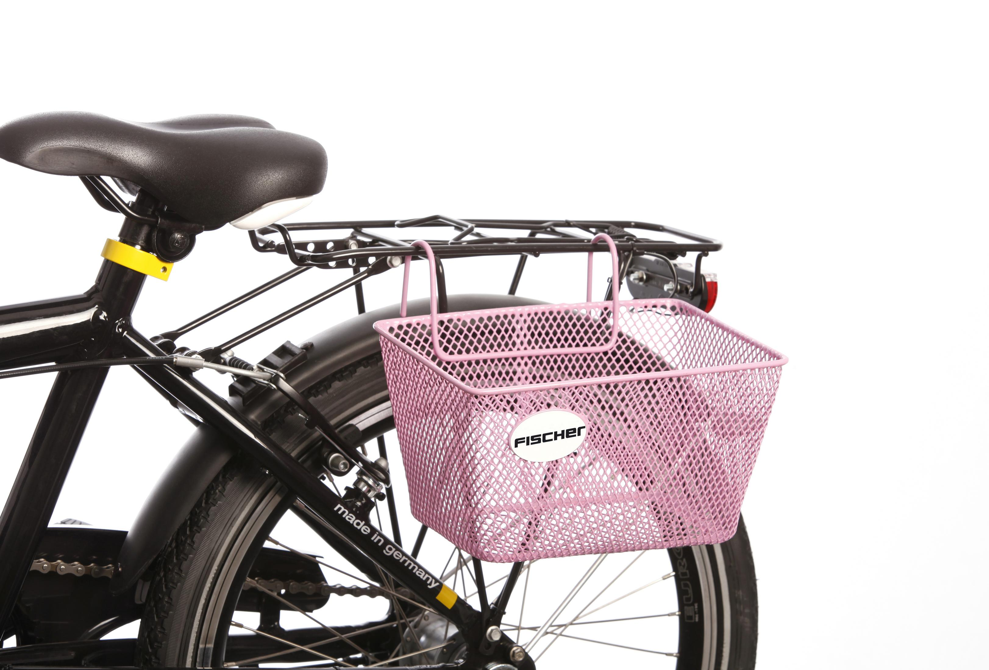 Rosafarbener Fahrradkorb aus Netz an einem schwarzen Fahrrad. Der Hintergrund ist weiß.