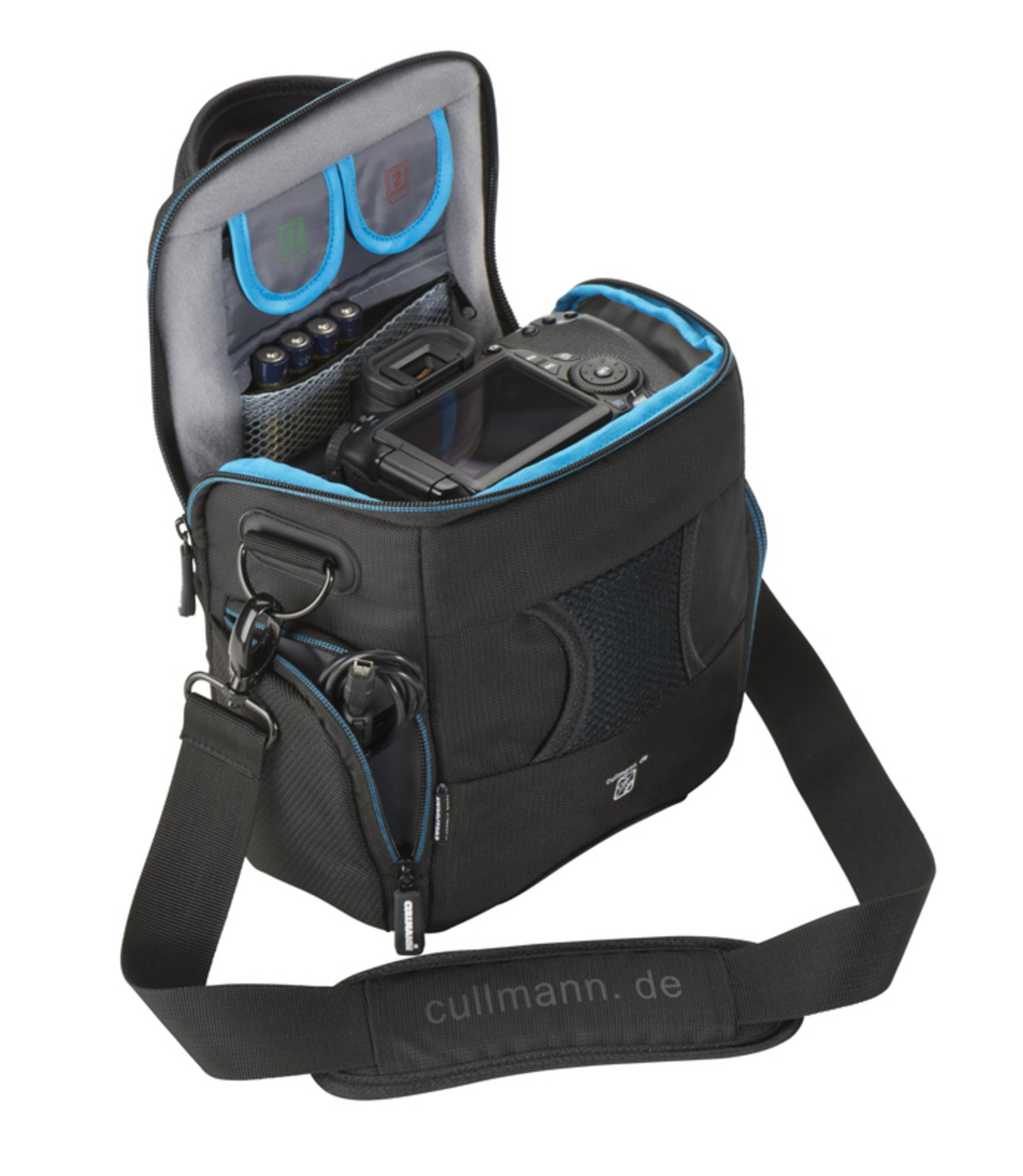 Eine schwarze Kameratasche mit blauem Innenraum. Eine Kamera und Zubehör befinden sich darin.