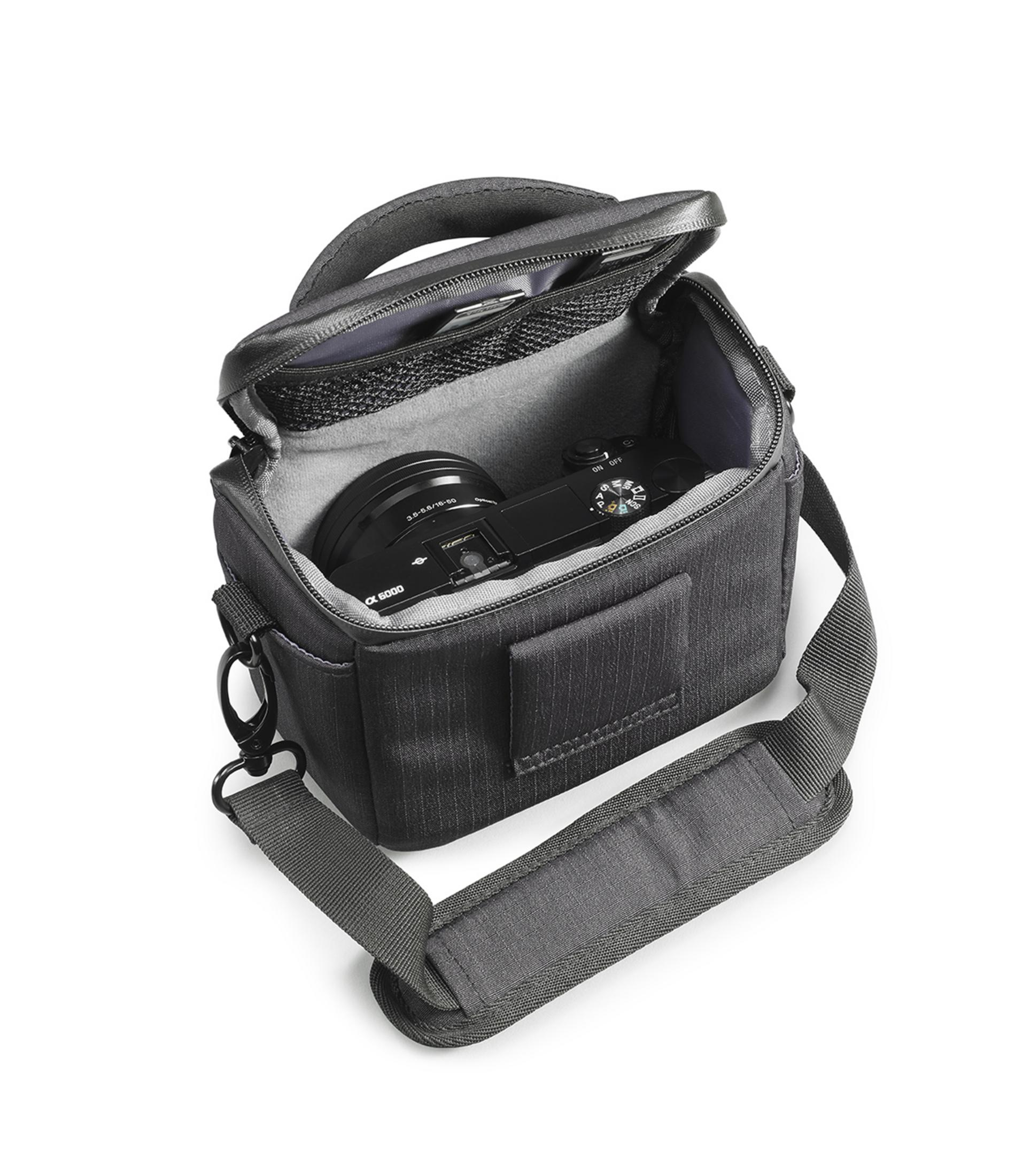 Schwarze Kameratasche, offen, mit einer Kamera darin. Weißer Hintergrund. Tasche hat einen Riemen.