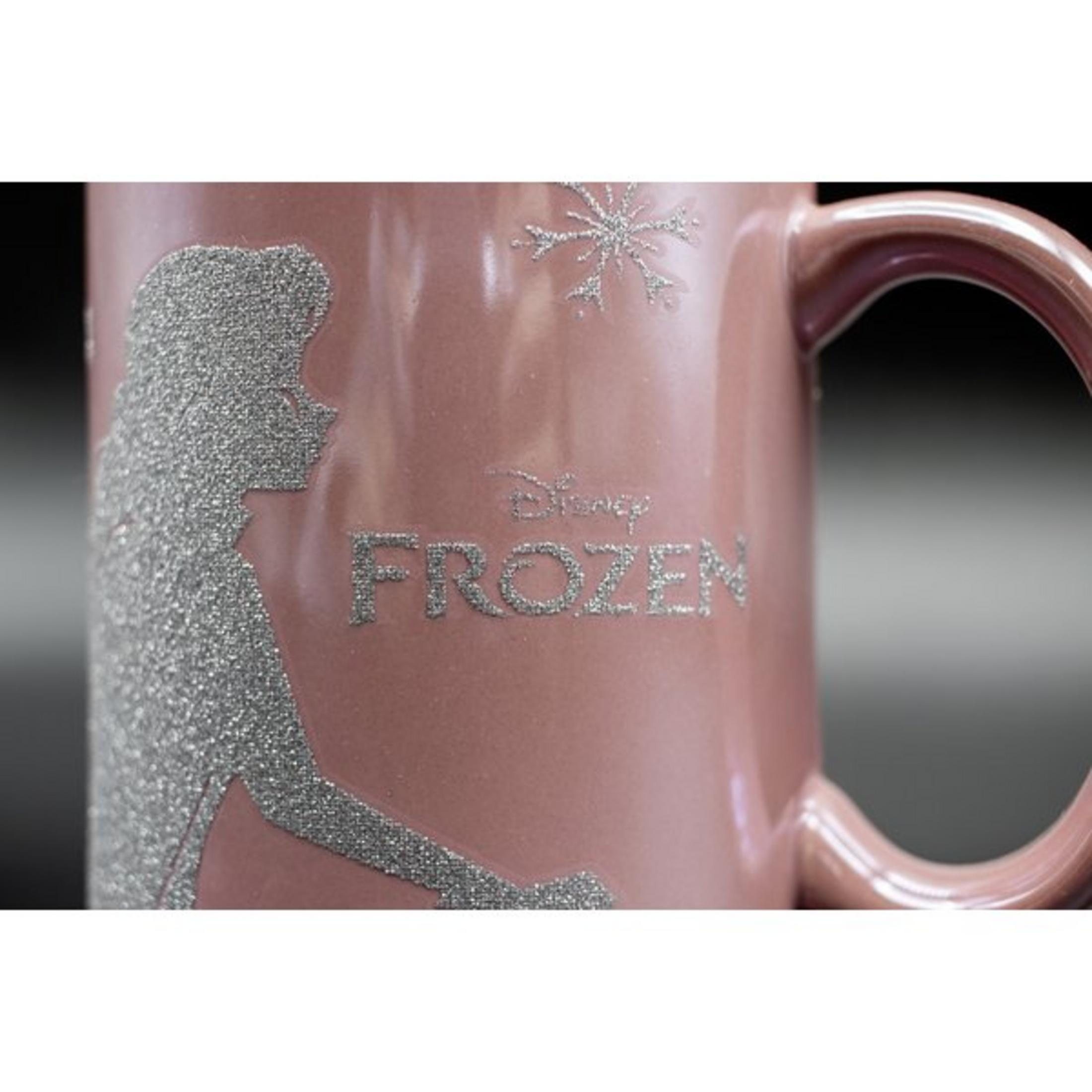 Rosa Tasse mit Elsa-Design und 'FROZEN' in silbernem Glitzer. Nahaufnahme der Tasse.