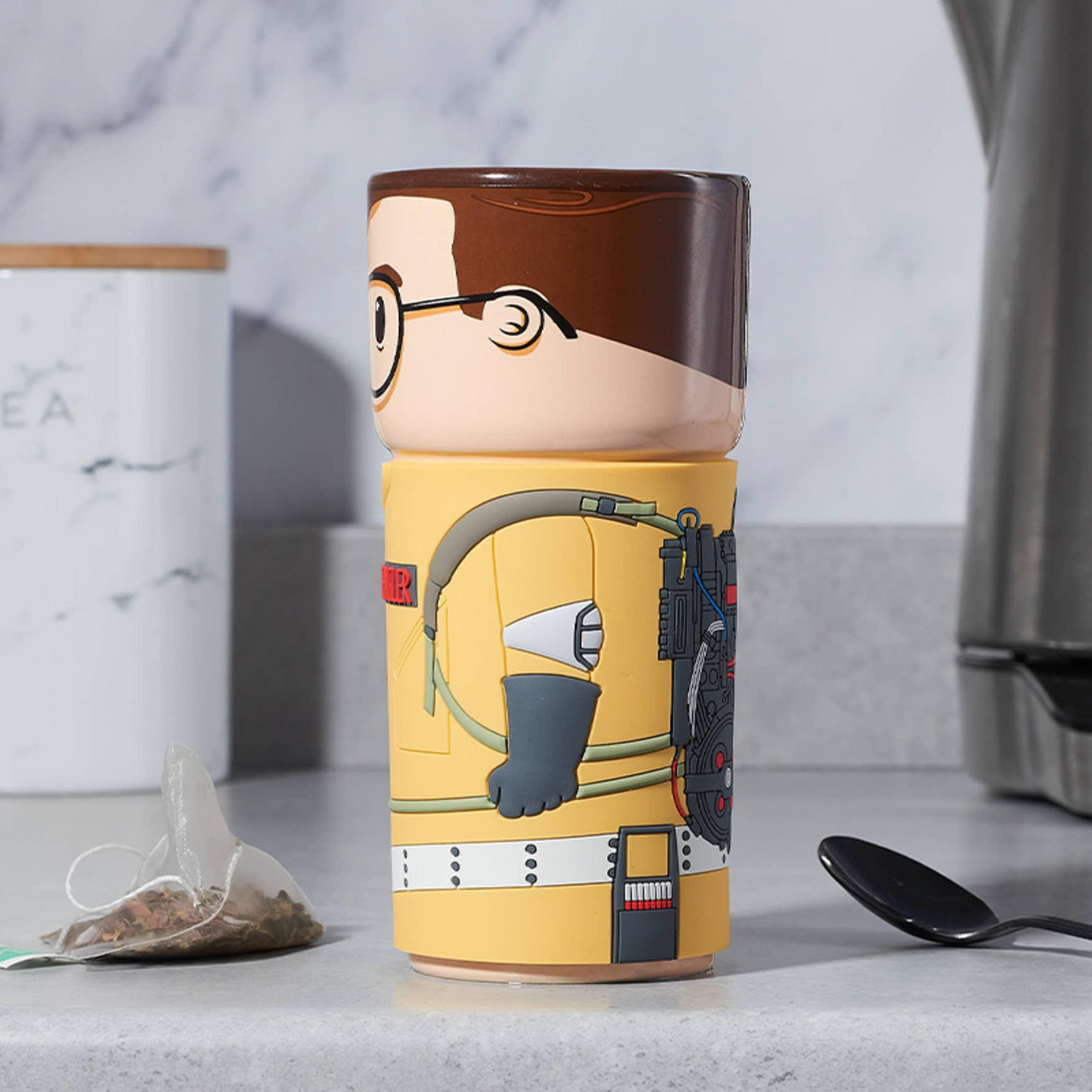 Ghostbusters-Tasse mit Teebeutel und Löffel. Sie steht auf einer weißen Arbeitsplatte.