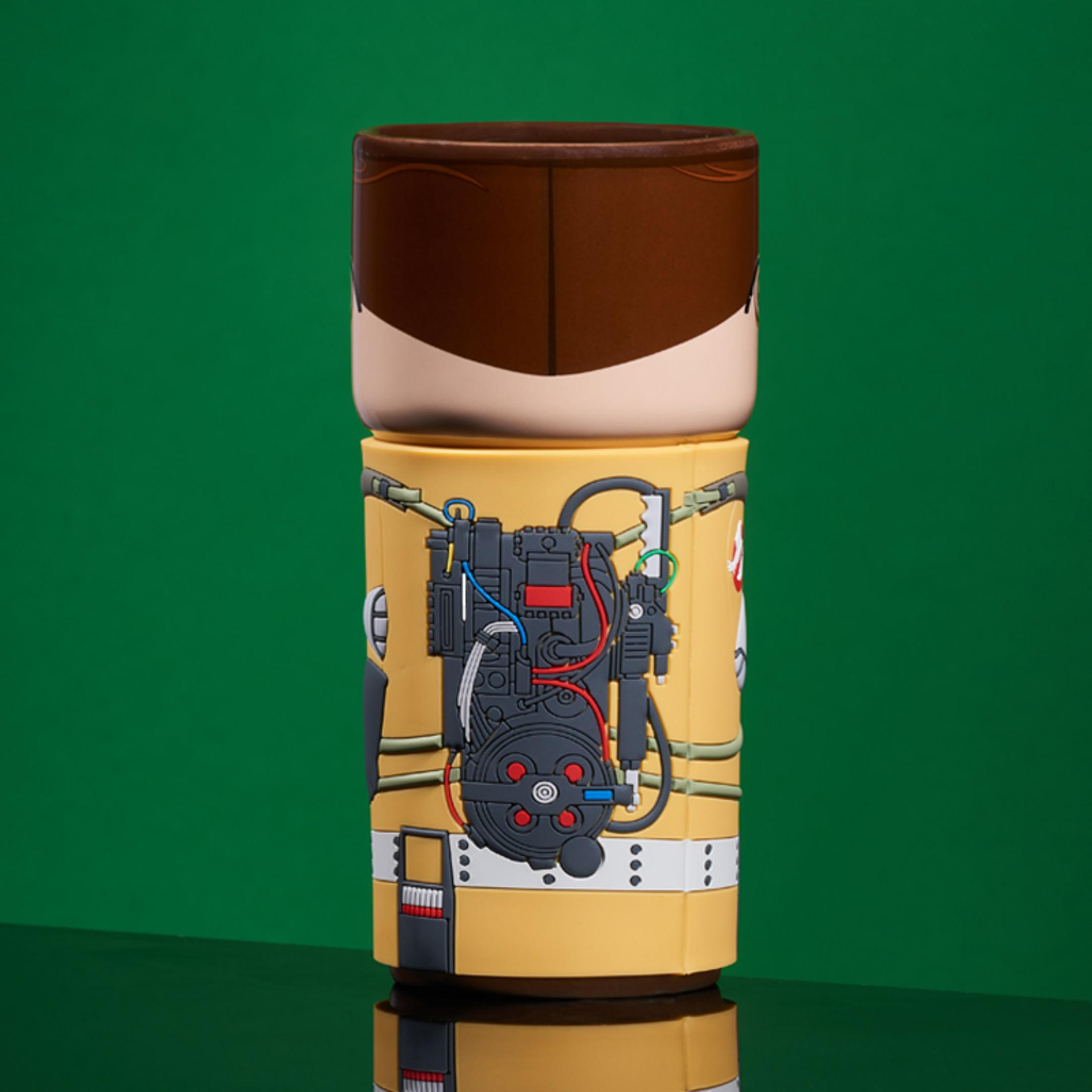 Ghostbusters-Becher. Gelbes Äußeres mit Protonenpack-Design, braunes Haar oben.