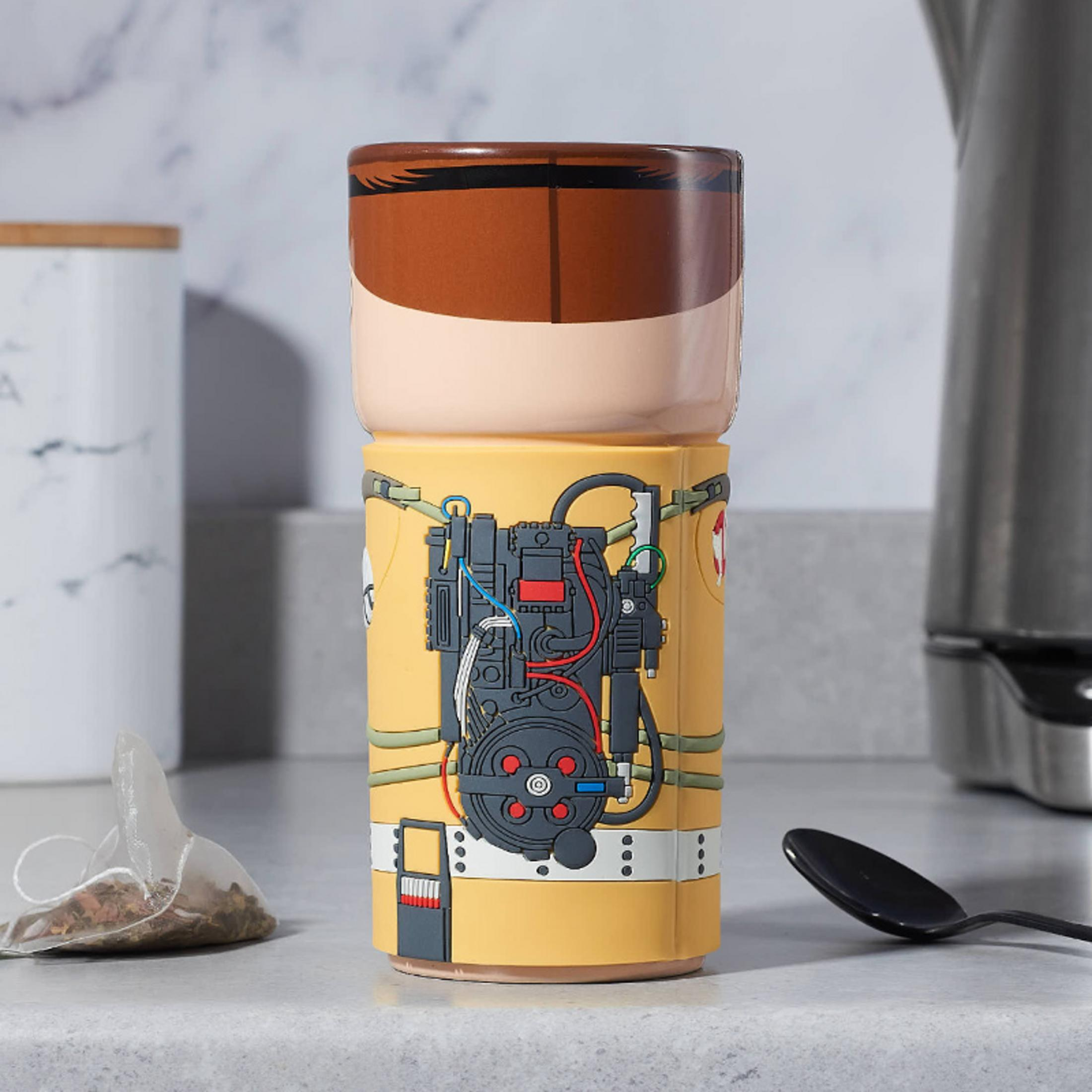 Eine Ghostbusters-Tasse mit Teebeutel und Löffel daneben.
