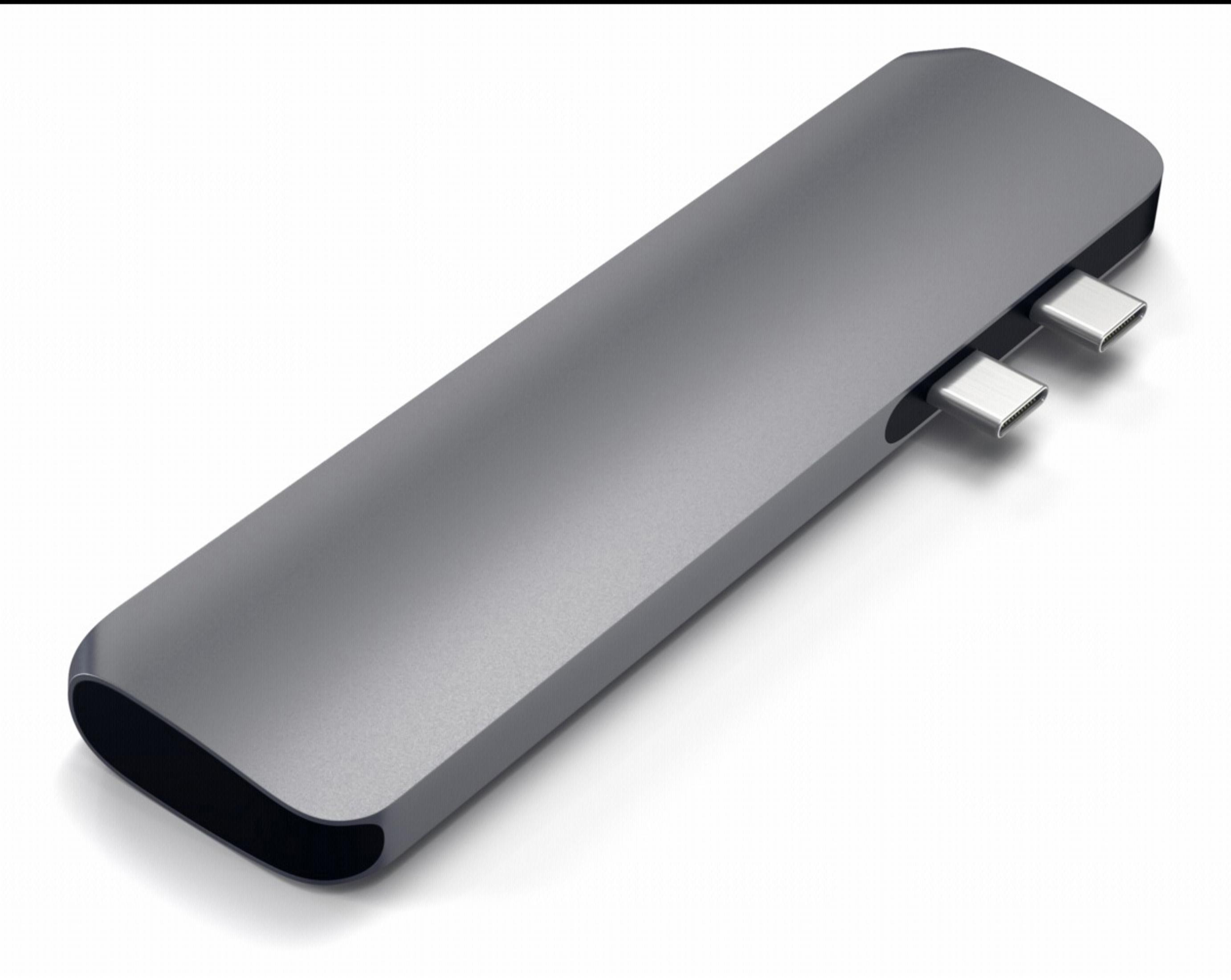 Un hub USB-C grigio con due porte su sfondo bianco. Ha una forma oblunga.