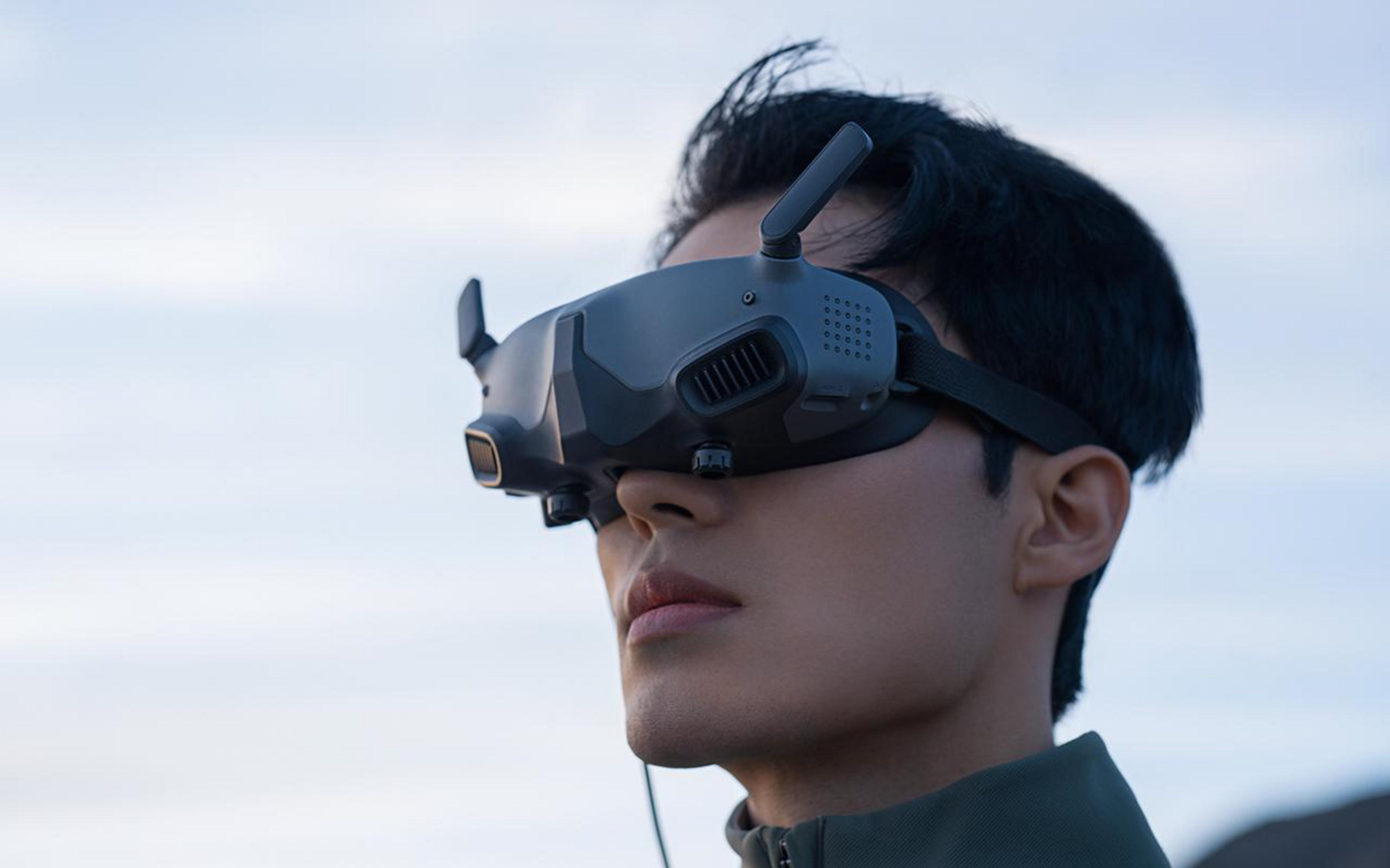 Mann mit VR-Headset, der nach oben schaut. Blauer Himmel im Hintergrund.