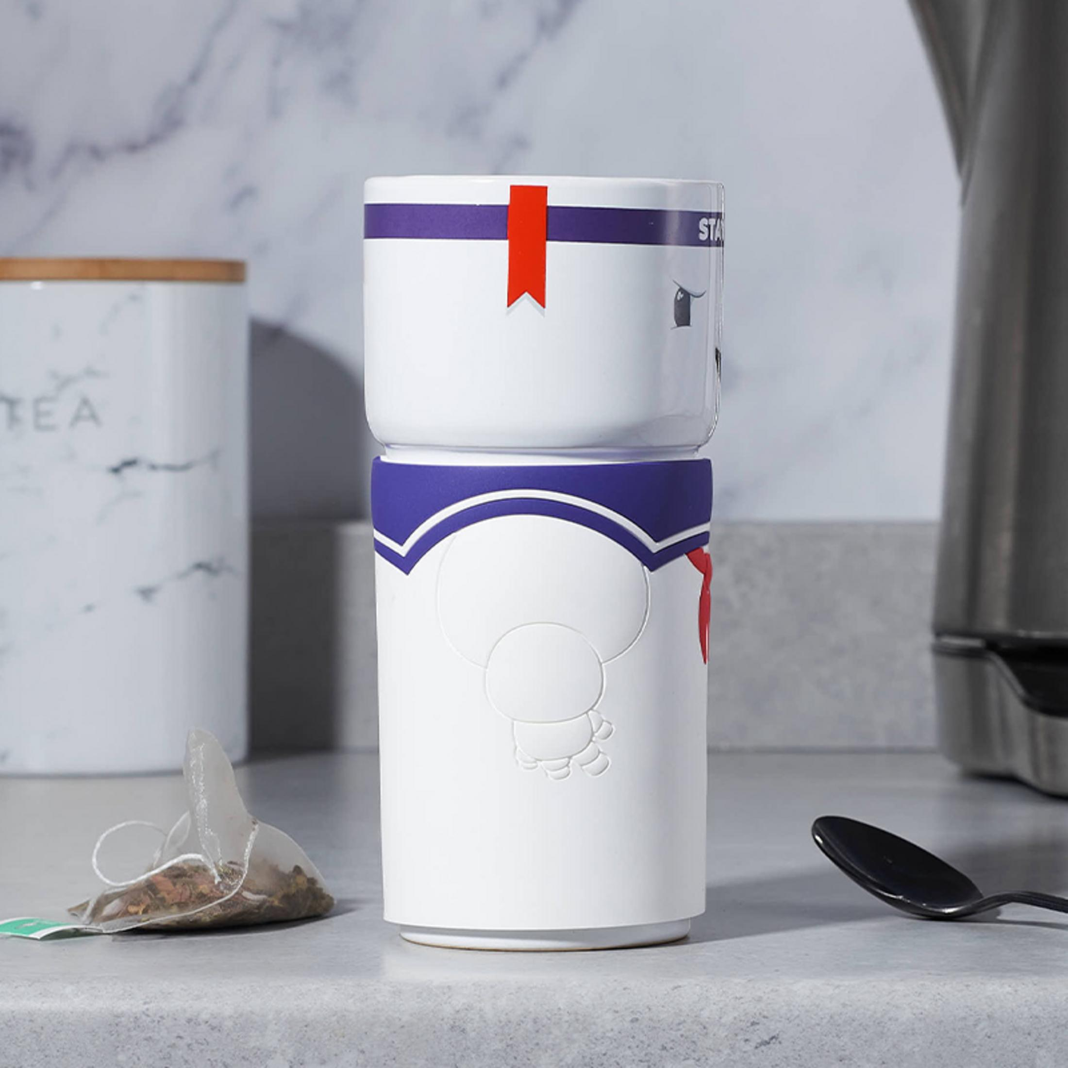 Weißer Stay Puft Marshmallow Man-Becher mit blauen und roten Akzenten. Küchentheke.
