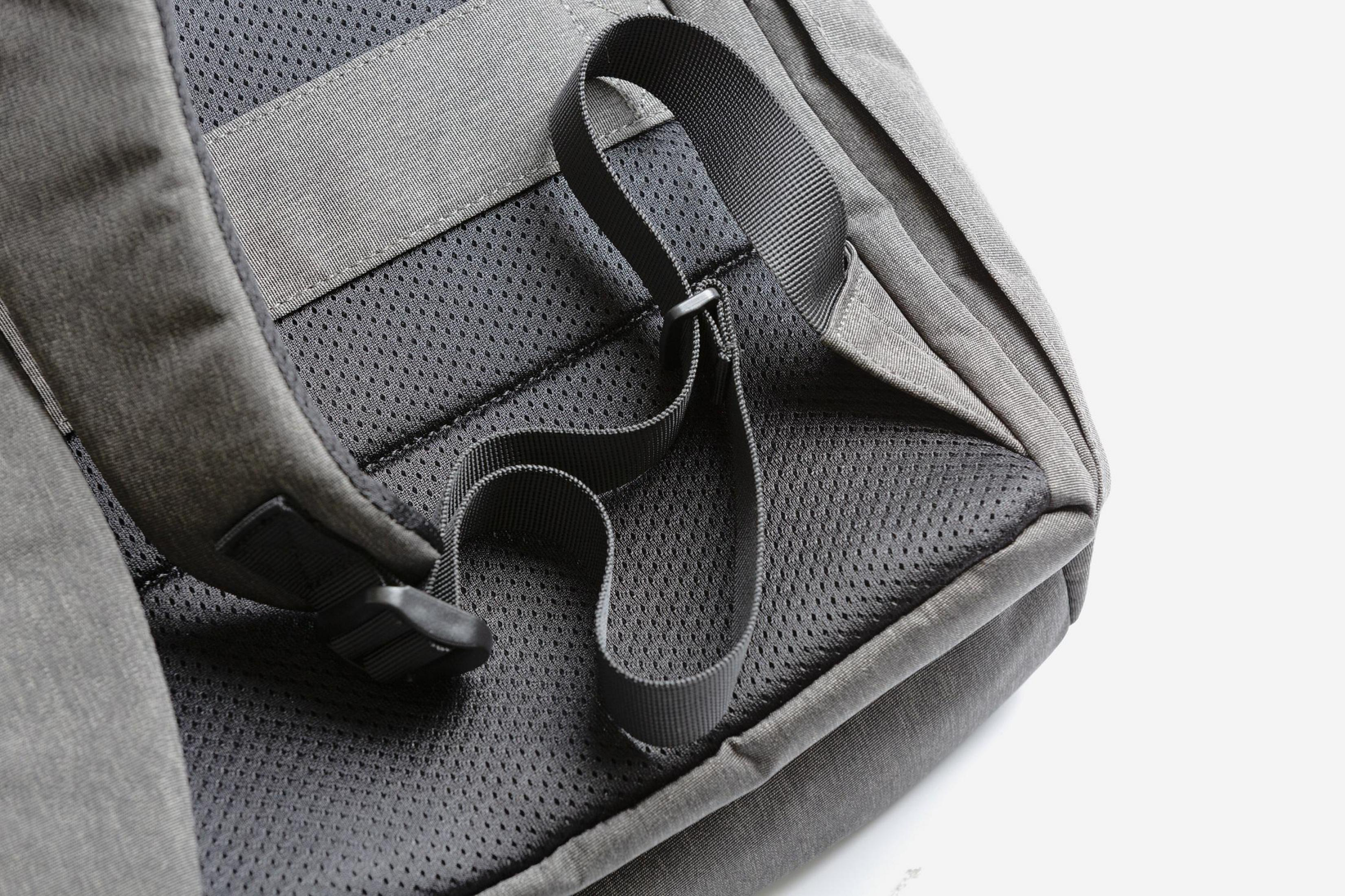 Nahaufnahme des Rückenteils eines grauen Rucksacks mit Gurten und Mesh-Details.