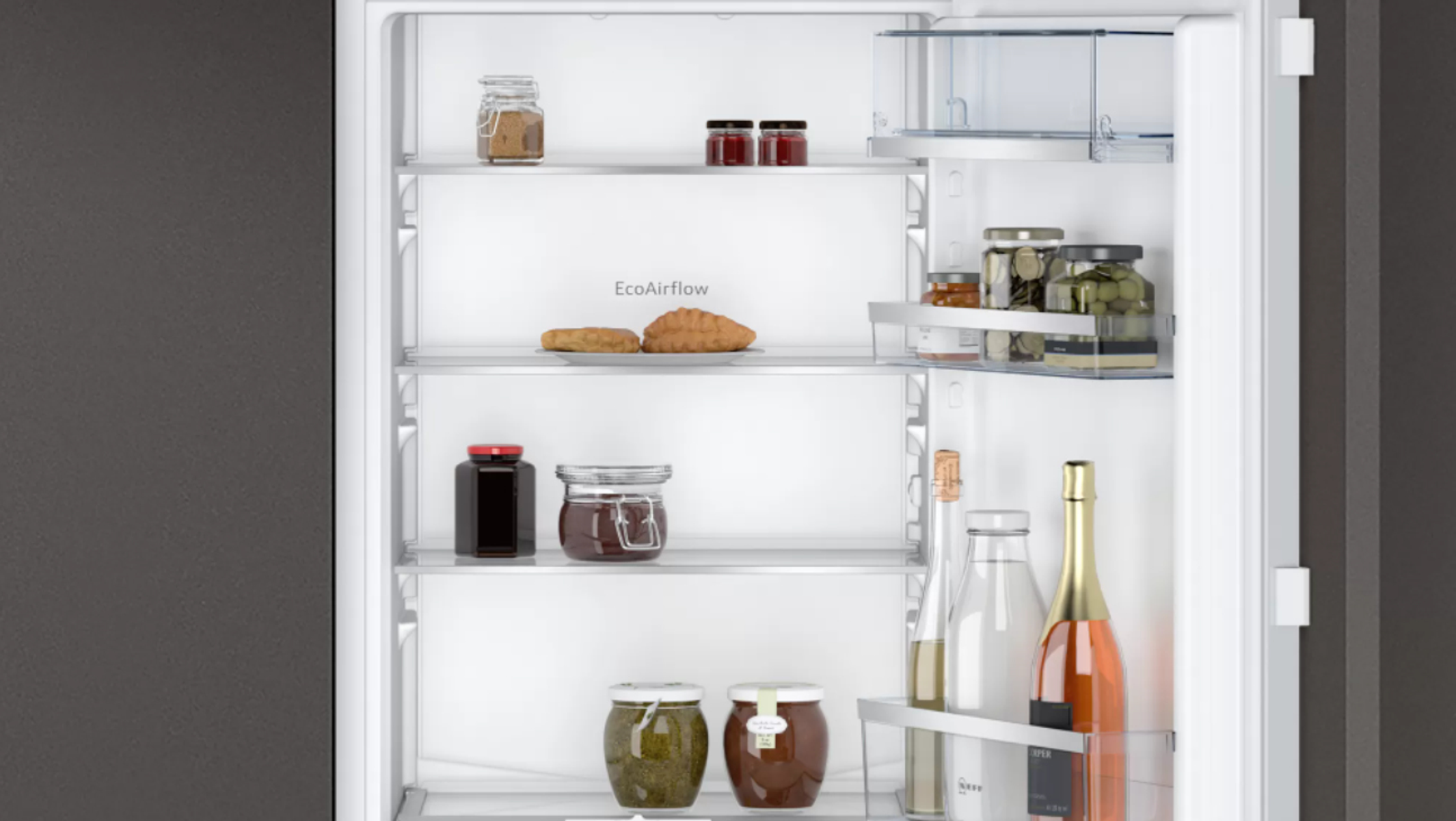 Offener Kühlschrank mit Regalen und Gläsern. Etwas Essen ist im Kühlschrank sichtbar.