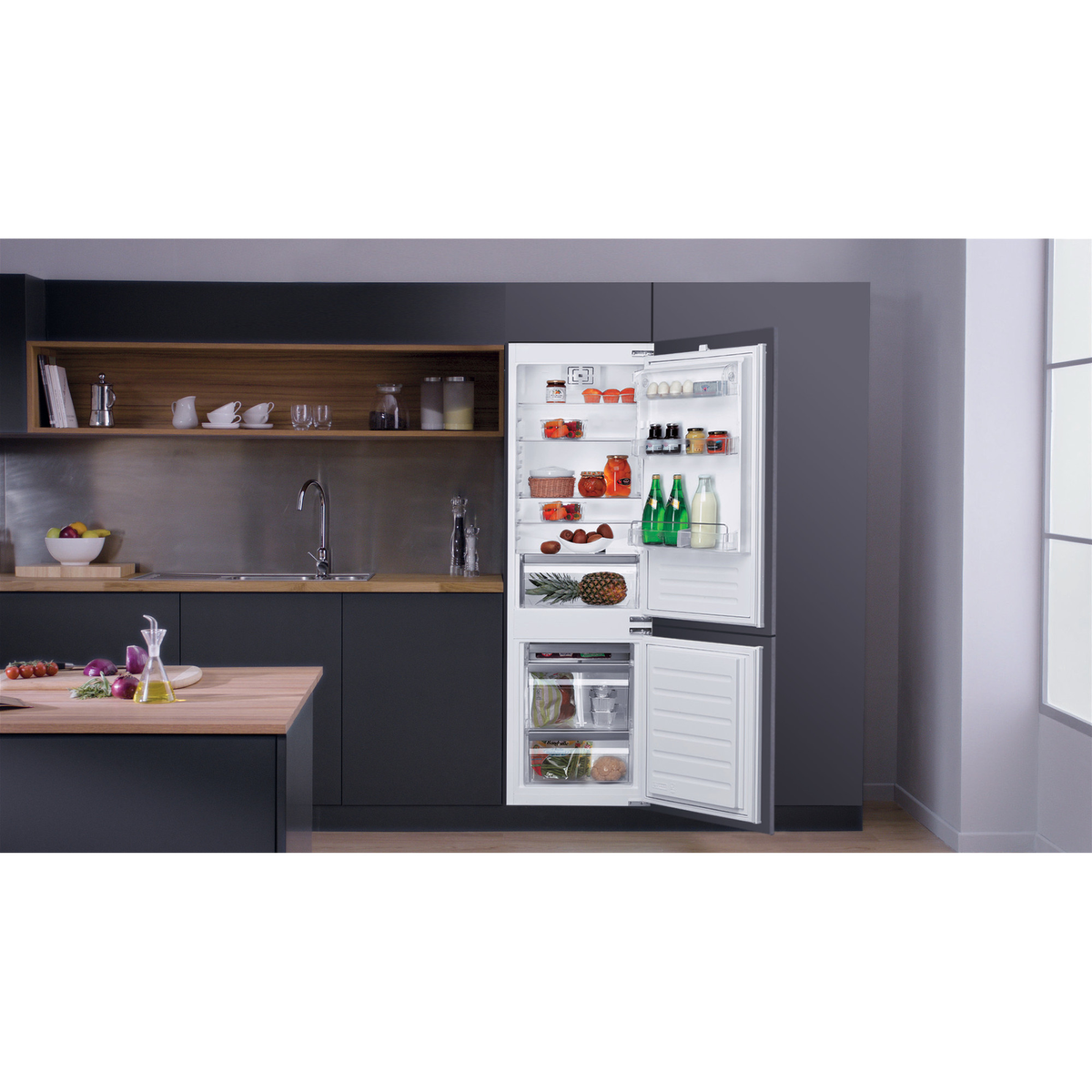 Ein offener Kühlschrank mit Lebensmitteln. Er hat verschiedene Regale mit Obst, Gemüse und anderen Lebensmitteln.