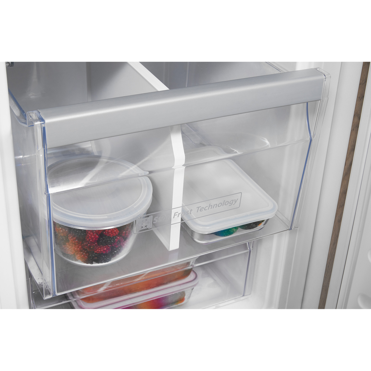 Innenraum eines Kühlschranks mit Behältern. Transparente Schubladen mit Essen darin.
