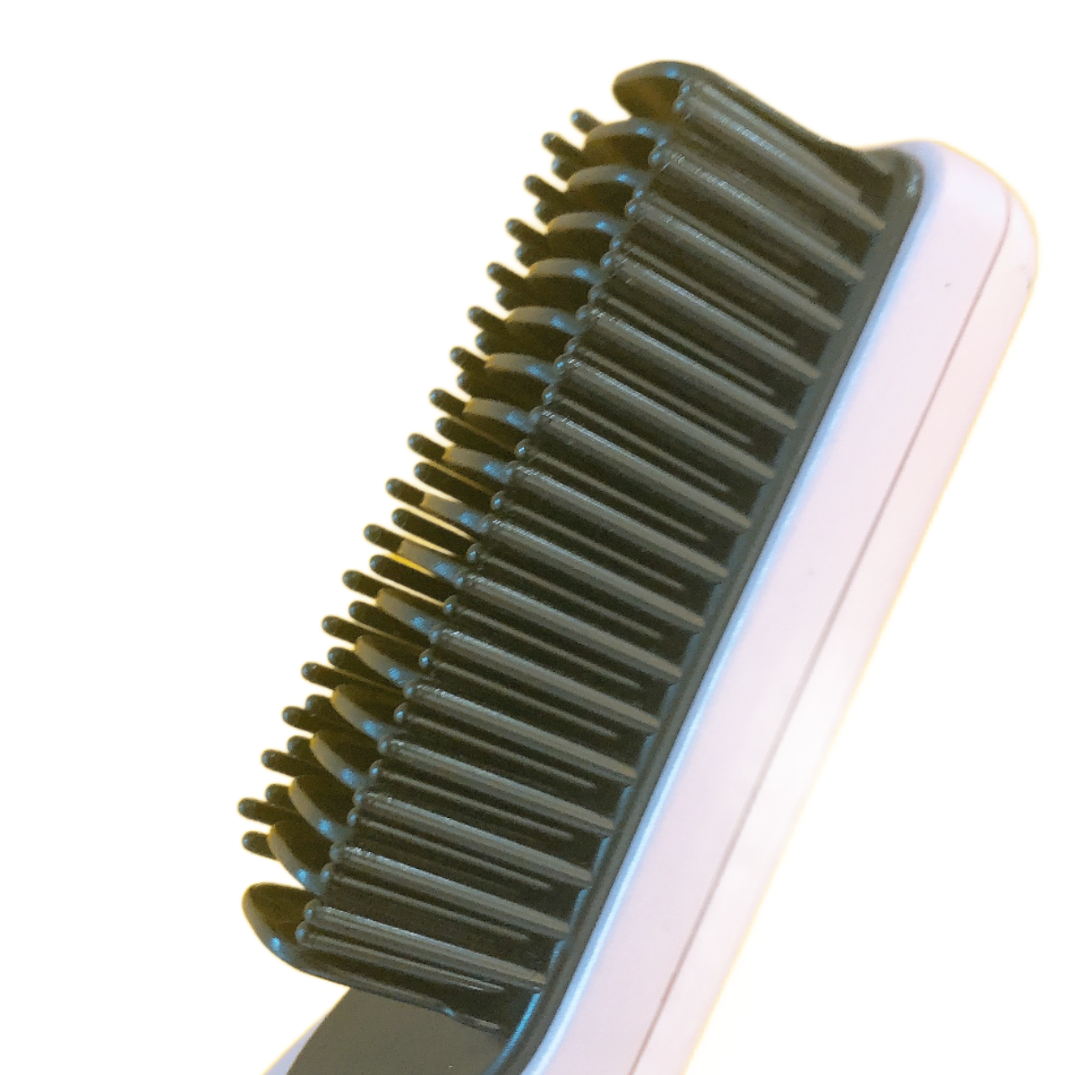 Nahaufnahme einer Haarglättungsbürste mit schwarzen Borsten auf einem weißen Griff.