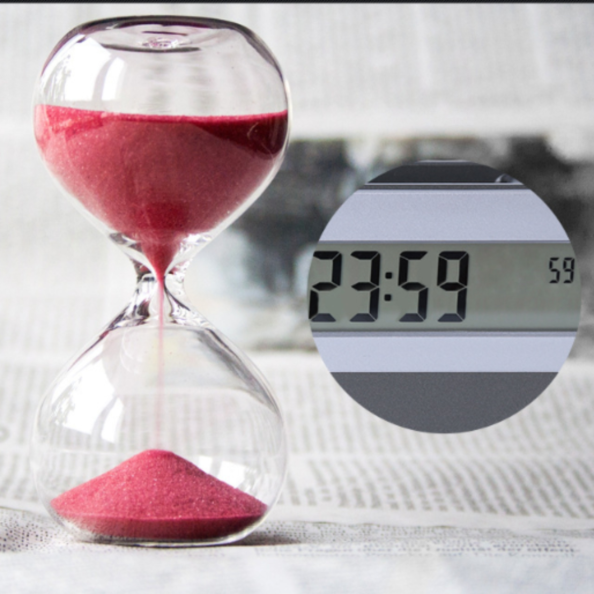 Sanduhr mit rotem Sand und eine Digitaluhr, die 23:59 und eine kleine Kreiszahl 59 anzeigt.
