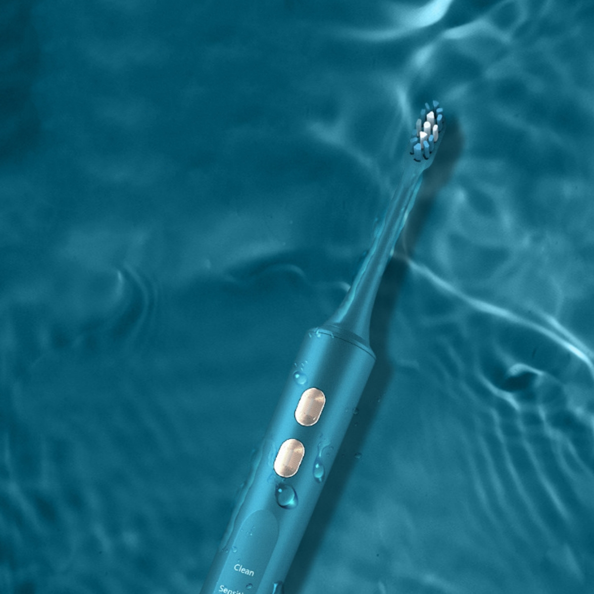 Türkisfarbene elektrische Zahnbürste im Wasser, Wassertropfen und Funktionstasten sichtbar.