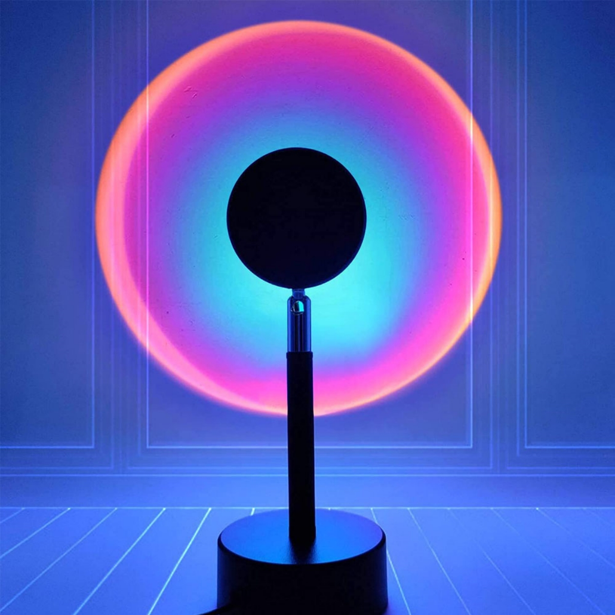 Eine Lampe projiziert ein kreisförmiges Licht mit einem mehrfarbigen Farbverlauf auf eine Wand.