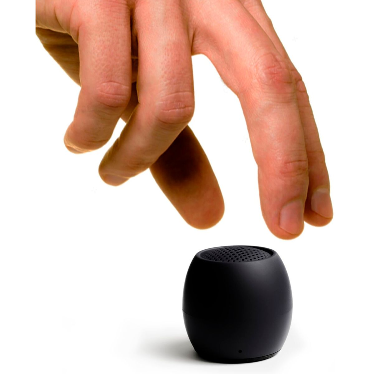 Ręka sięgająca do małego, czarnego głośnika w kształcie owalu. Tło jest białe.