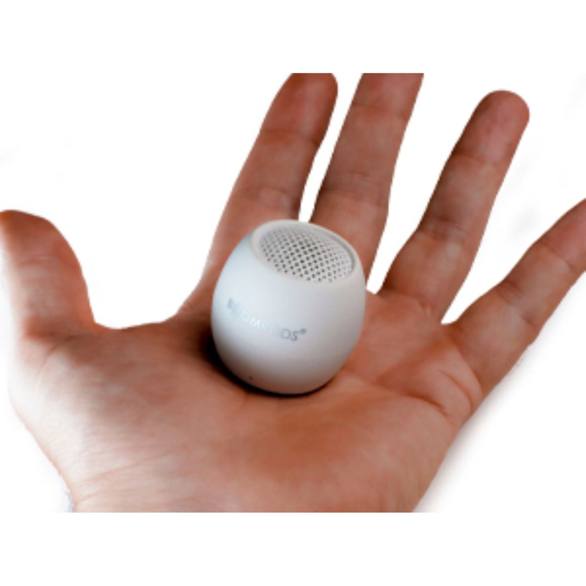 Mały biały głośnik w dłoni. Kulisty kształt z siatką na górze.