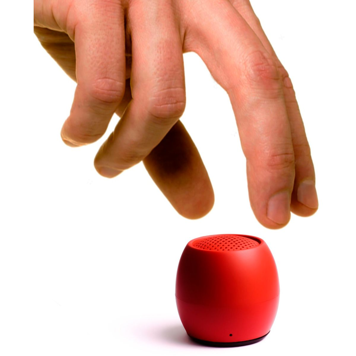 Dłoń sięgająca po mały, czerwony głośnik na białym tle.