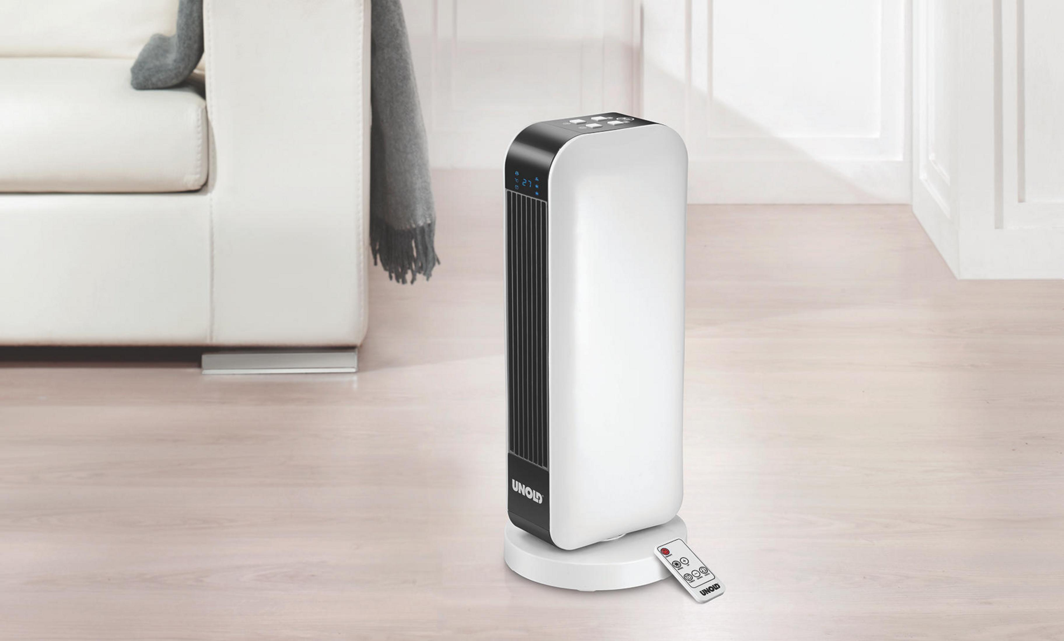 Biało-czarny wentylator wieżowy z pilotem na białej podstawie, na drewnianej podłodze.