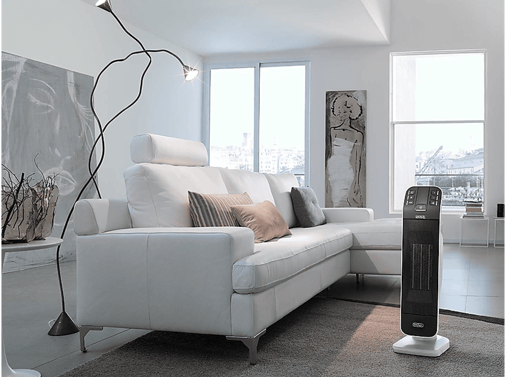 Biała sofa z poduszkami, lampa i grzejnik w nowoczesnym pokoju.