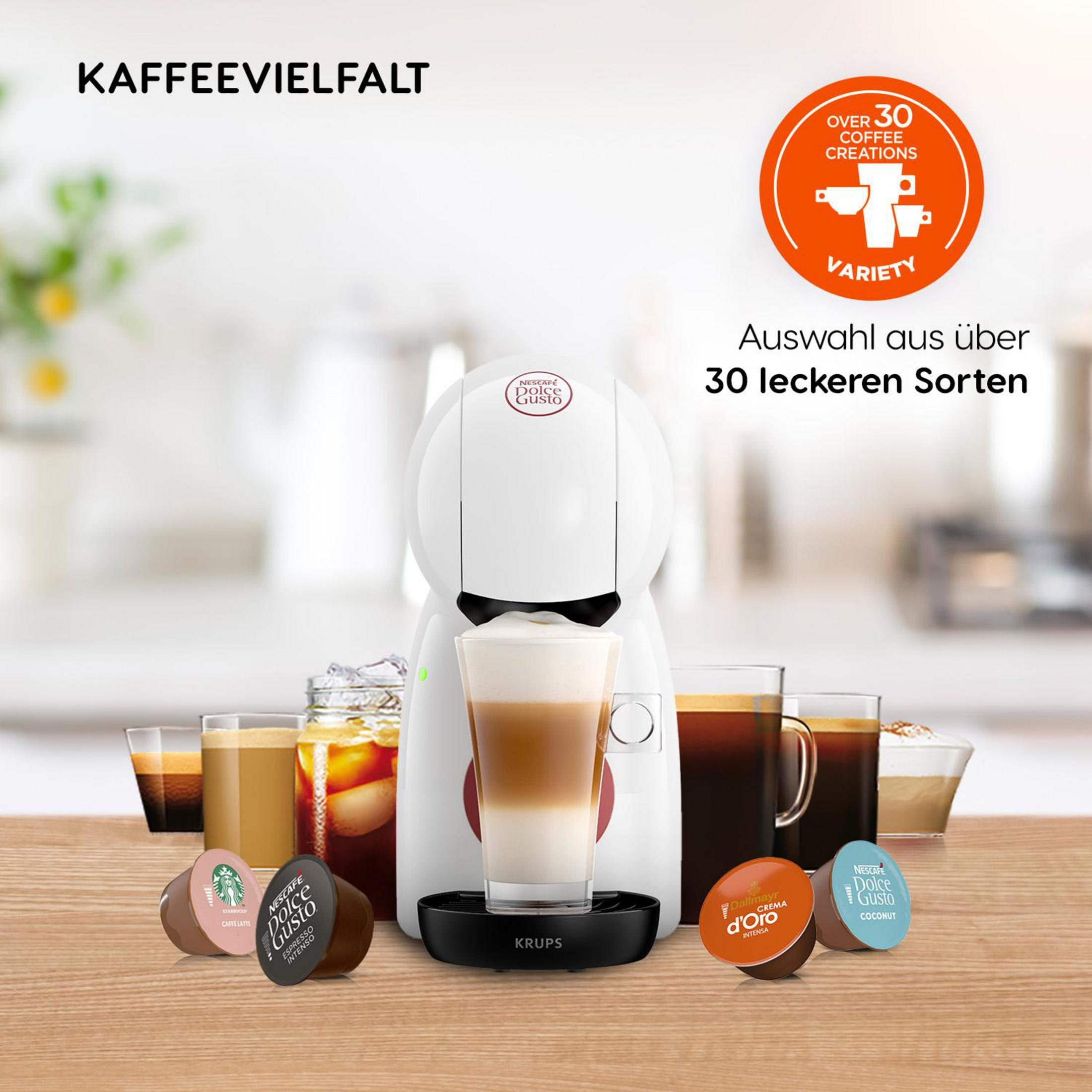 Una macchina da caffè bianca con cialde di caffè e varie bevande al caffè su un tavolo di legno.