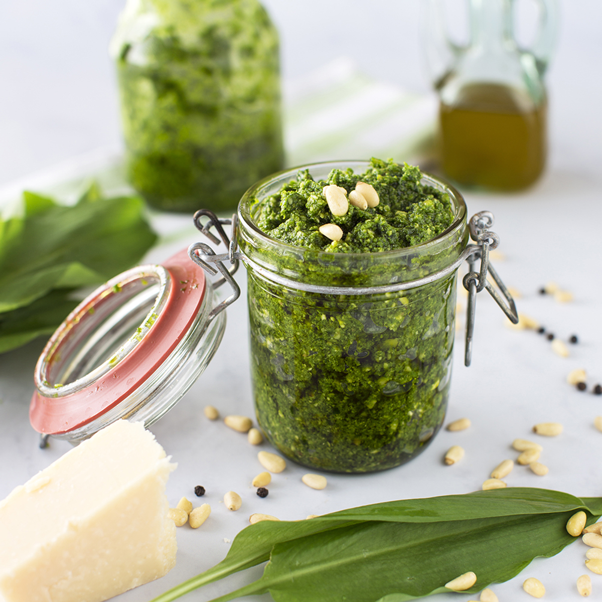 Pesto in einem Glas, mit Pinienkernen, Käse und Basilikumblättern.