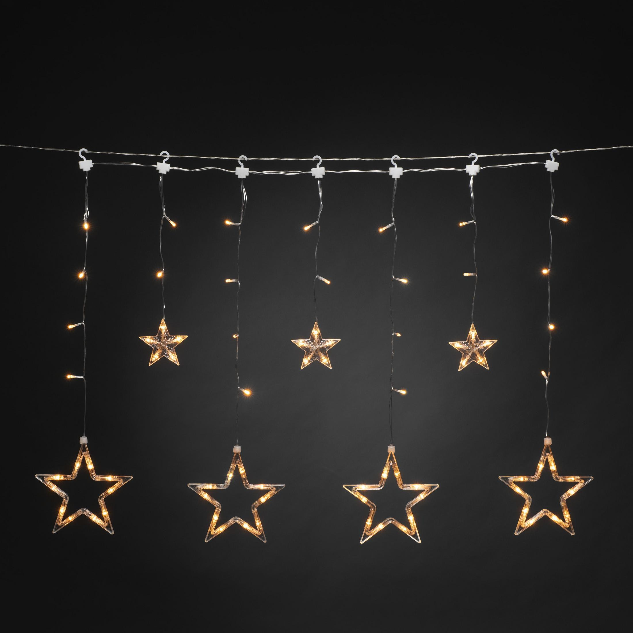 Lichterkette mit sternförmigen Lichtern vor schwarzem Hintergrund.