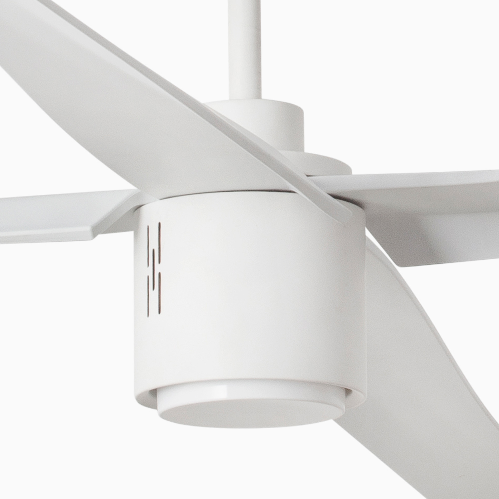 Primo piano di un ventilatore da soffitto bianco. Ha 4 pale e un alloggiamento motore cilindrico. Sfondo bianco.