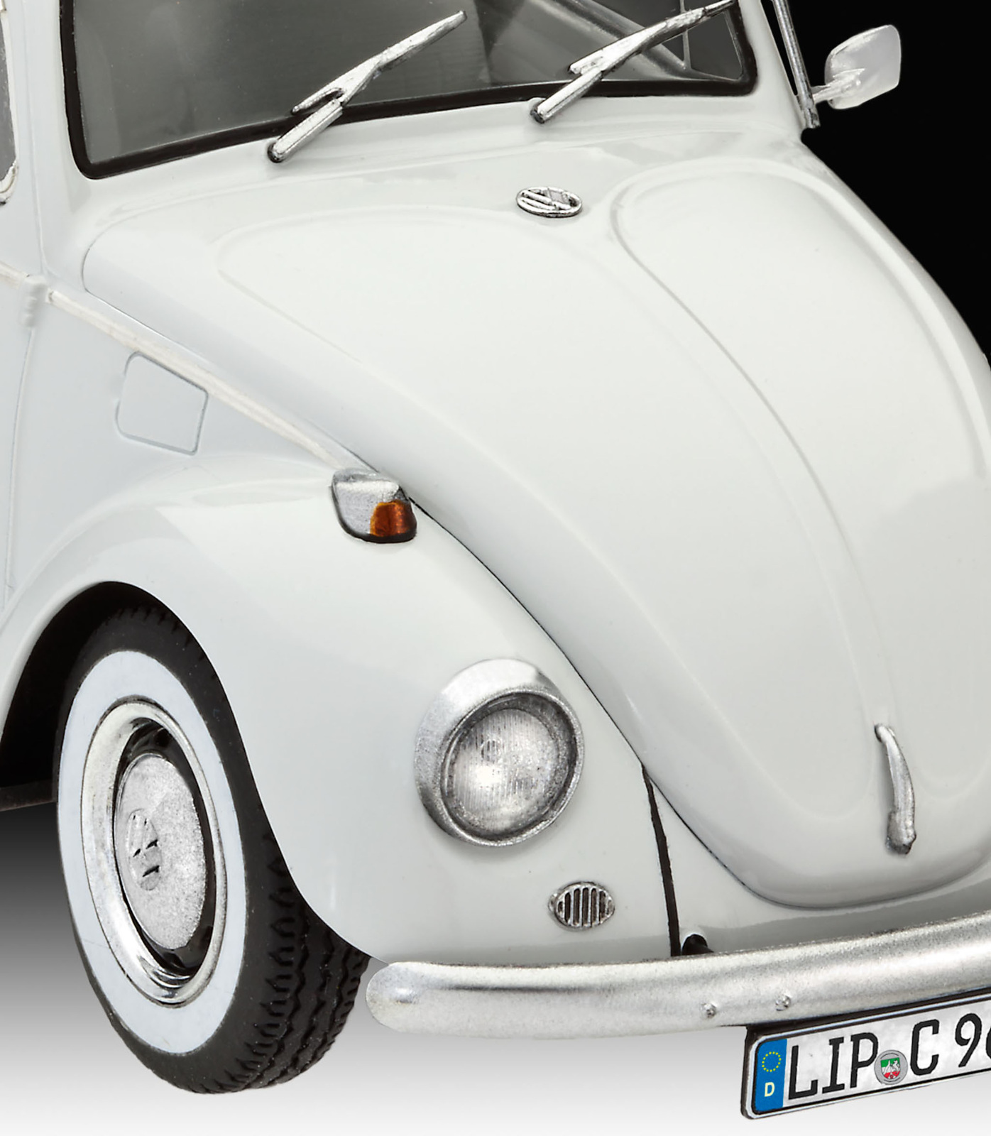 Witte oldtimer, vooraanzicht. Koplamp, bumper en kentekenplaat zijn zichtbaar.