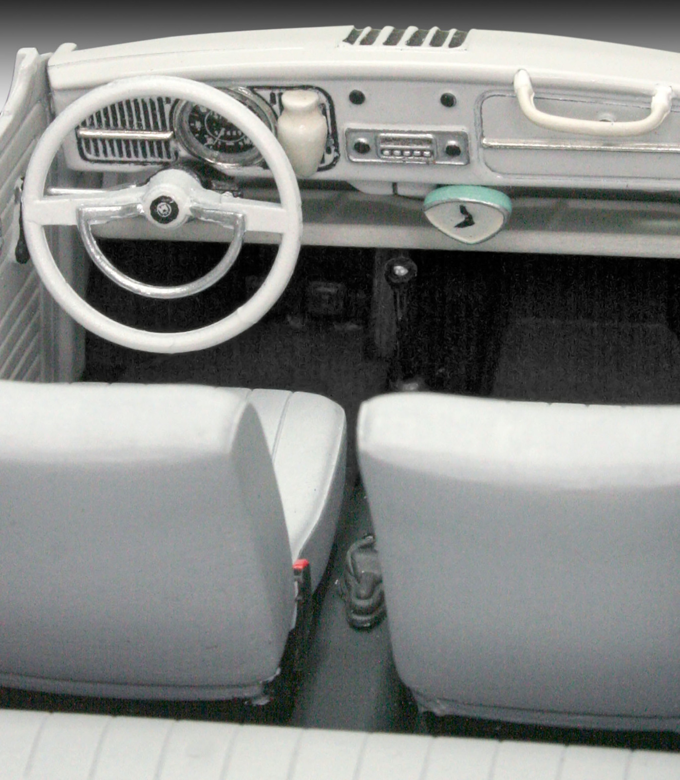Interieur van een klassieke witte auto: dashboard, stuur, stoelen en details van het interieur.