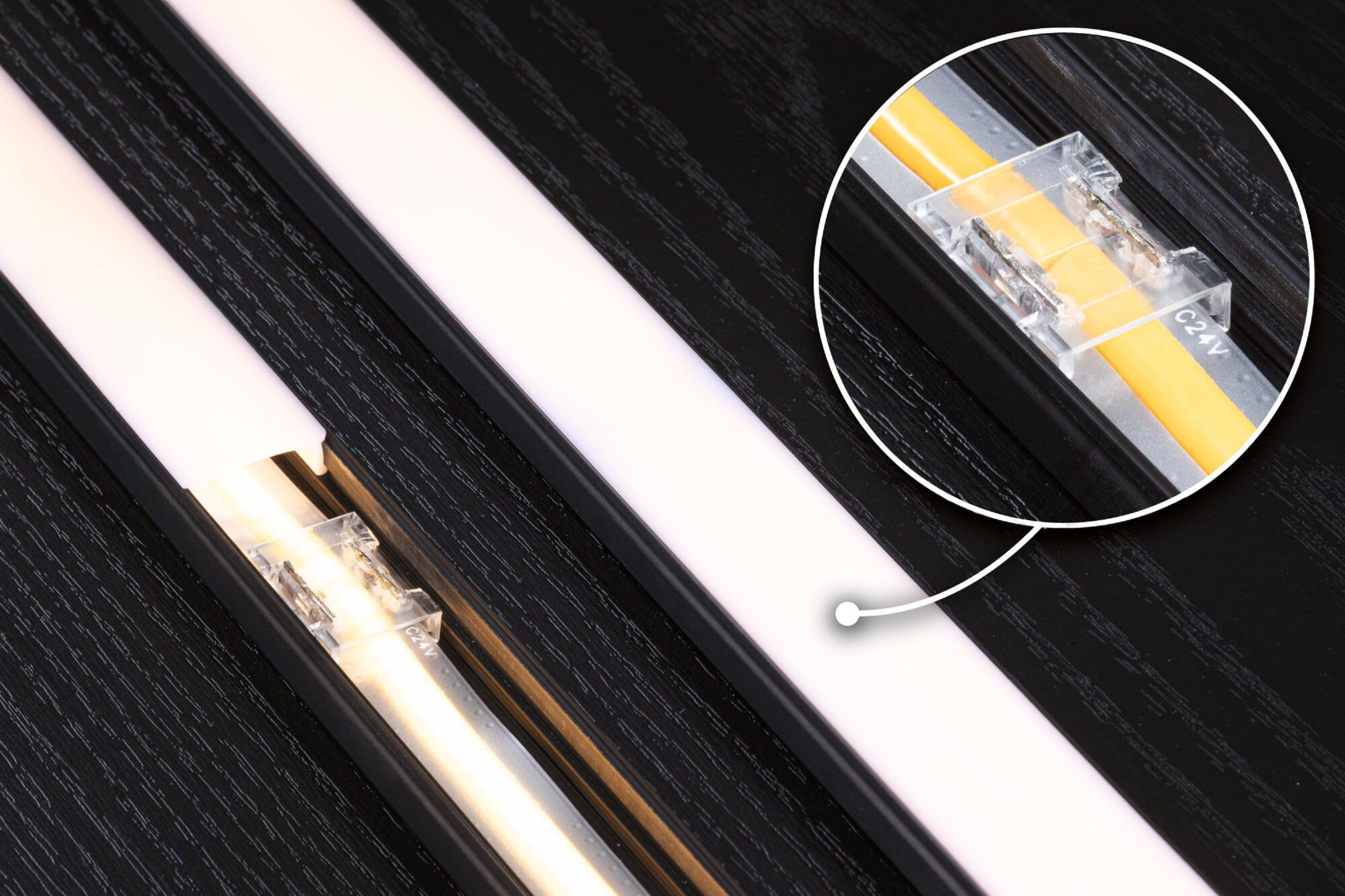 Zbliżenie listew LED, ze złączem, na czarnej powierzchni.