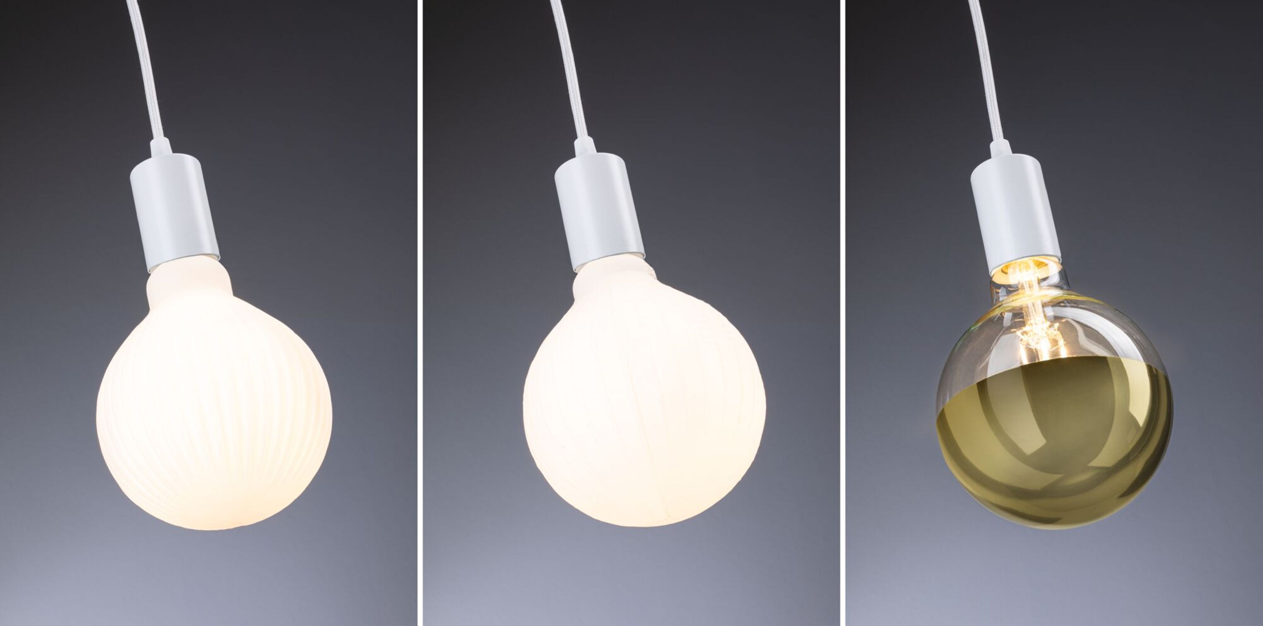 Trzy żarówki, jedna z rowkami, jedna gładka i jedna z żółtym płynem. Białe tło.
