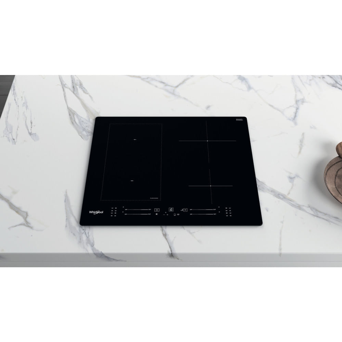 Un piano cottura a induzione nero su una superficie di marmo bianco. Il piano cottura ha un logo Whirlpool e comandi touch.