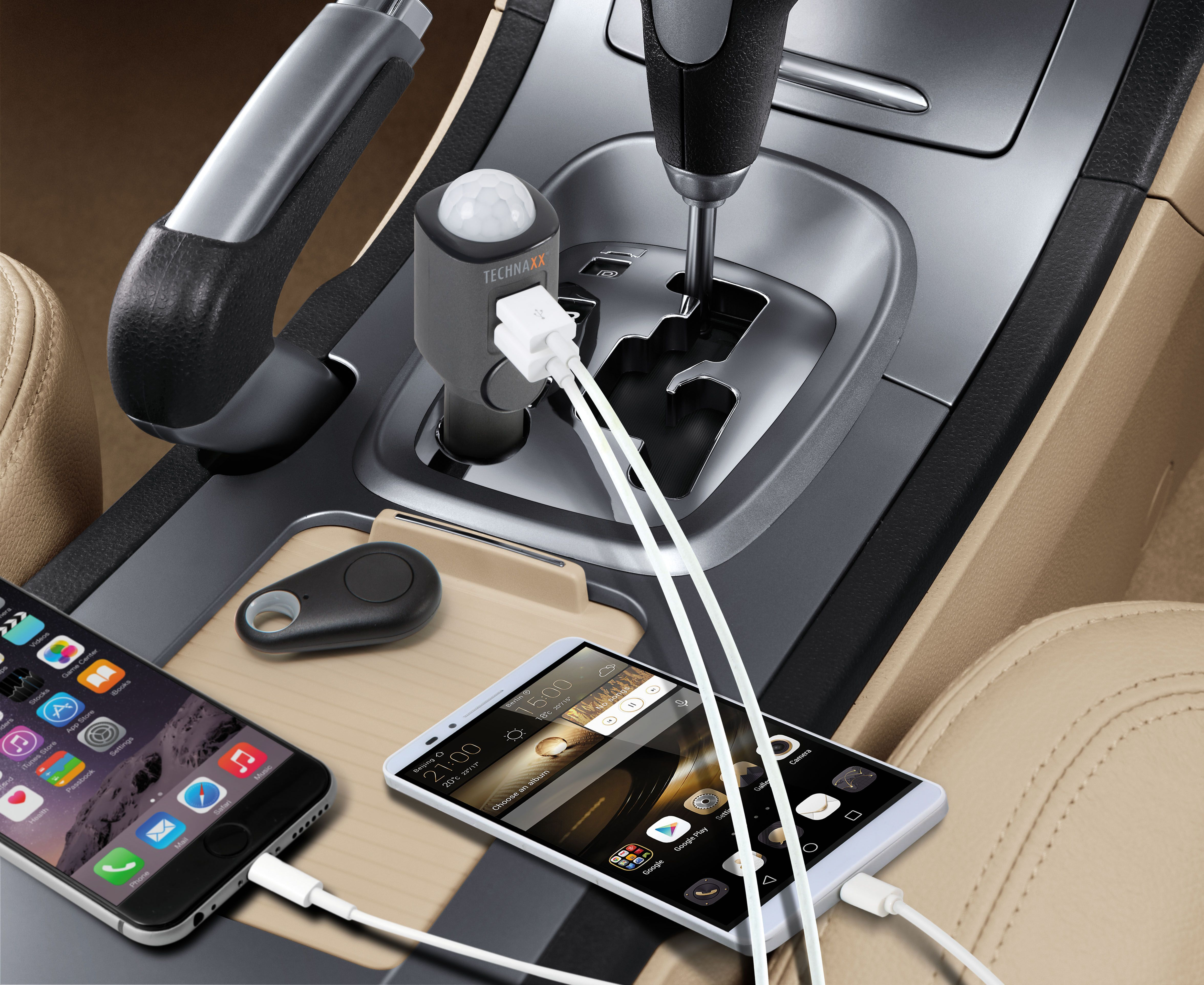 Autointerieur: Handys laden, Autoladegerät und Schlüsselanhänger, mit einem Schalthebel im Hintergrund.