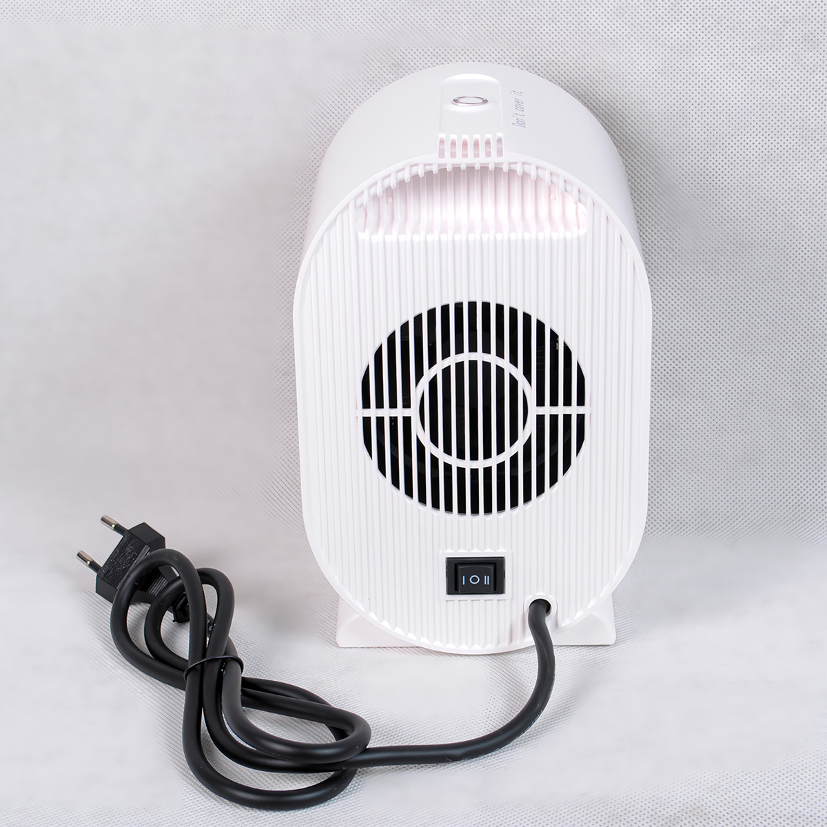 Calentador eléctrico blanco con cable y interruptor negros. Vista trasera, sobre superficie blanca.