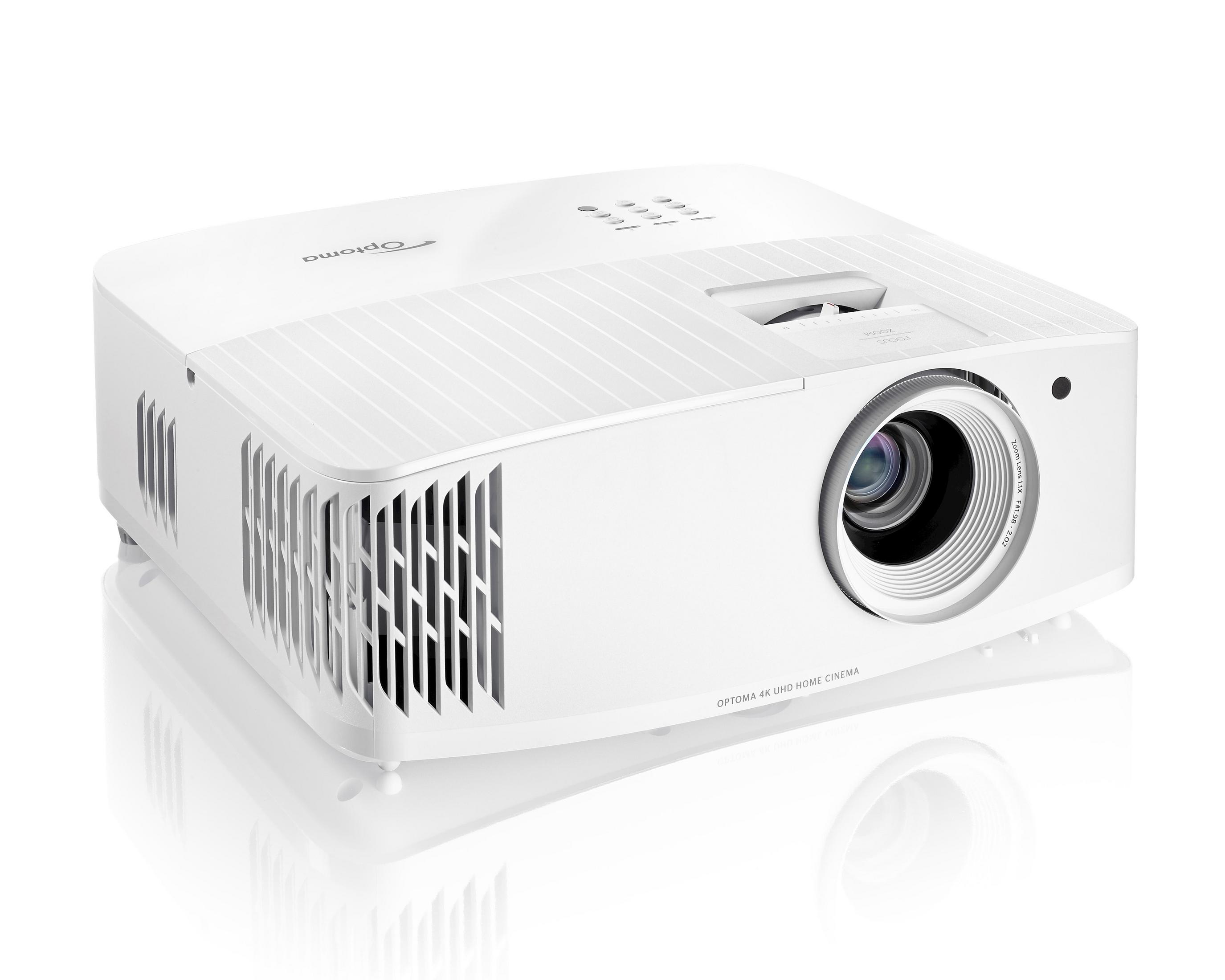 Un proyector blanco con ventilación y lente sobre una superficie blanca.
