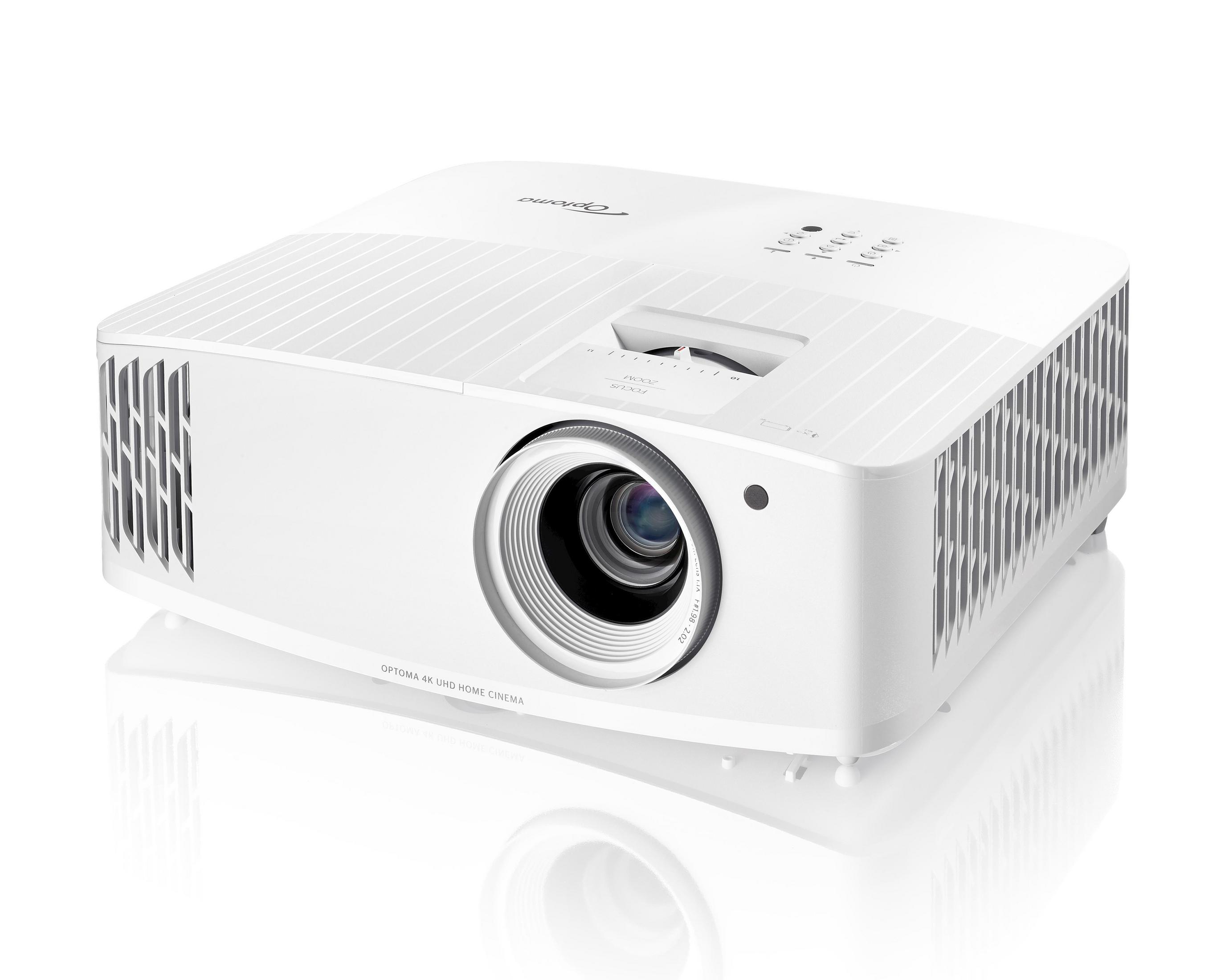 Un proyector blanco sobre una superficie blanca. Tiene una lente y algunas ranuras.