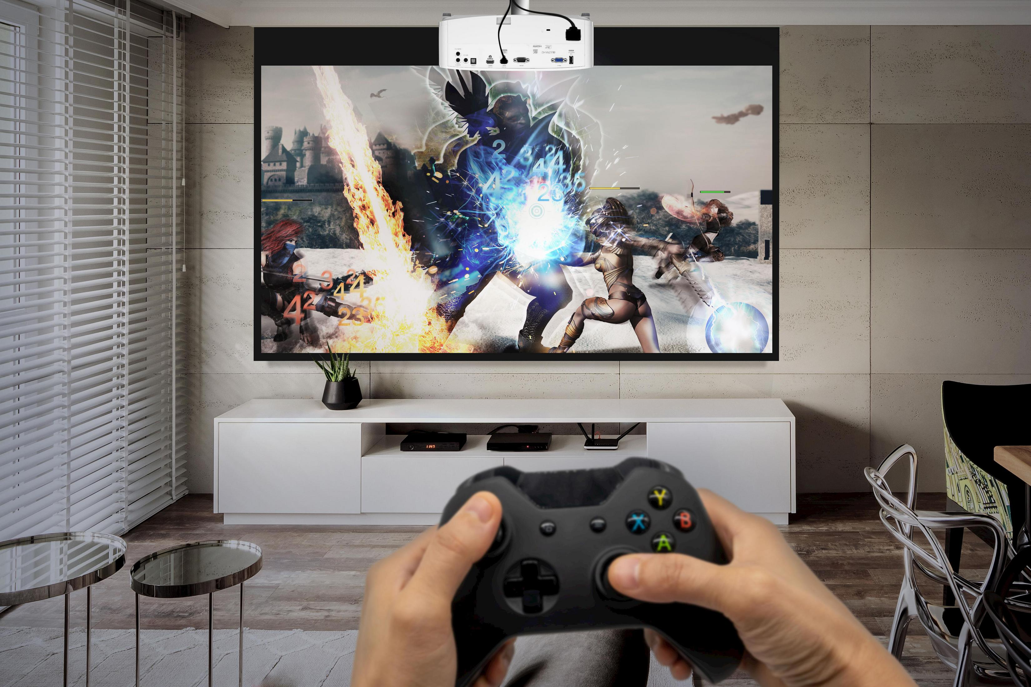 Persona jugando videojuego en pantalla grande con proyector.