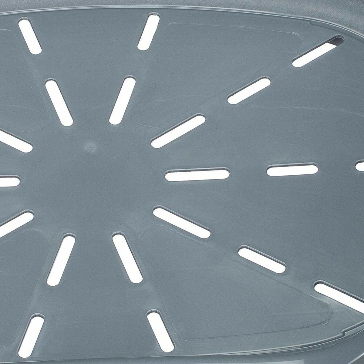 Primo piano di uno scolapasta in plastica grigia con numerosi fori oblunghi.