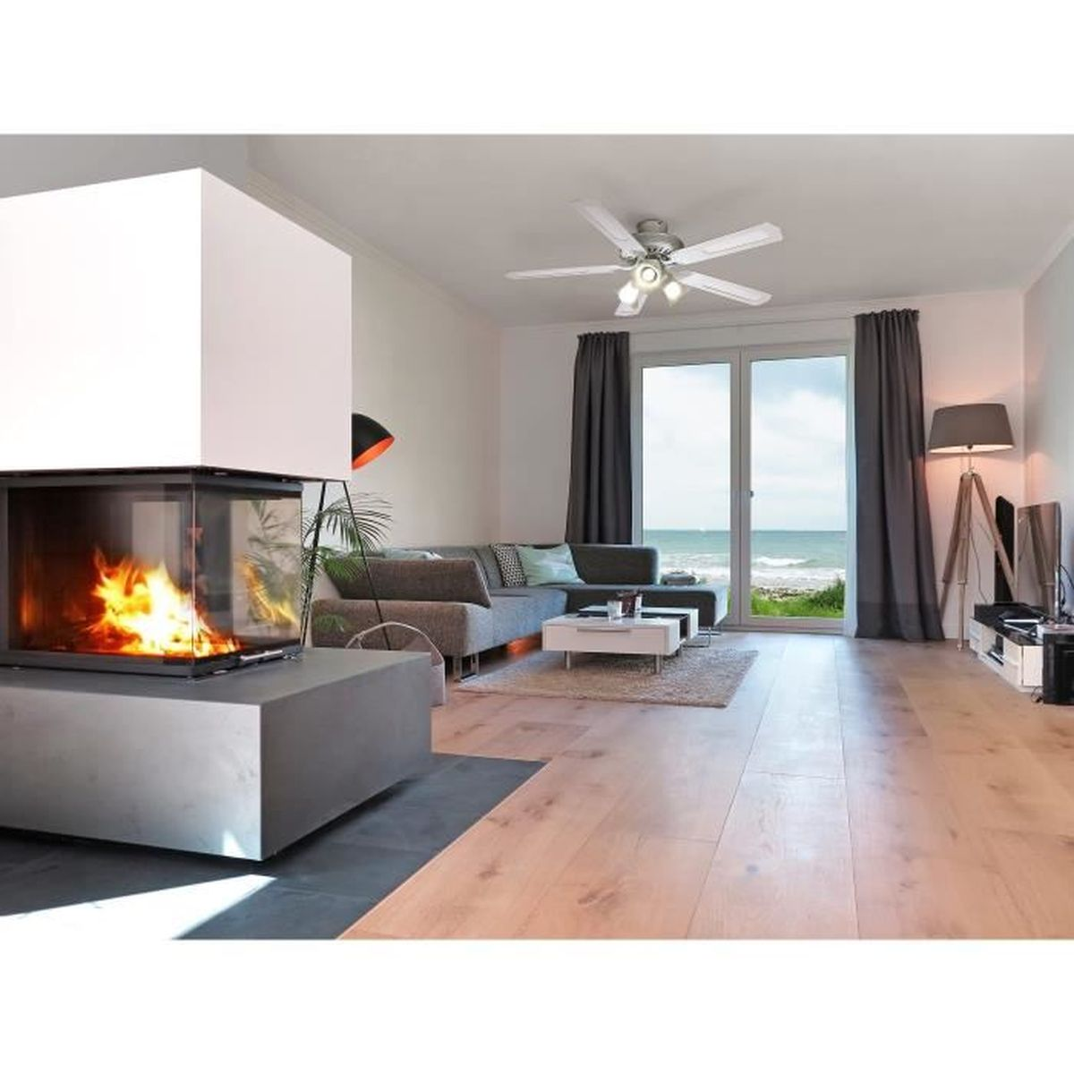 Living room with fireplace, sofa, coffee table, and a view of the ocean through large windows.