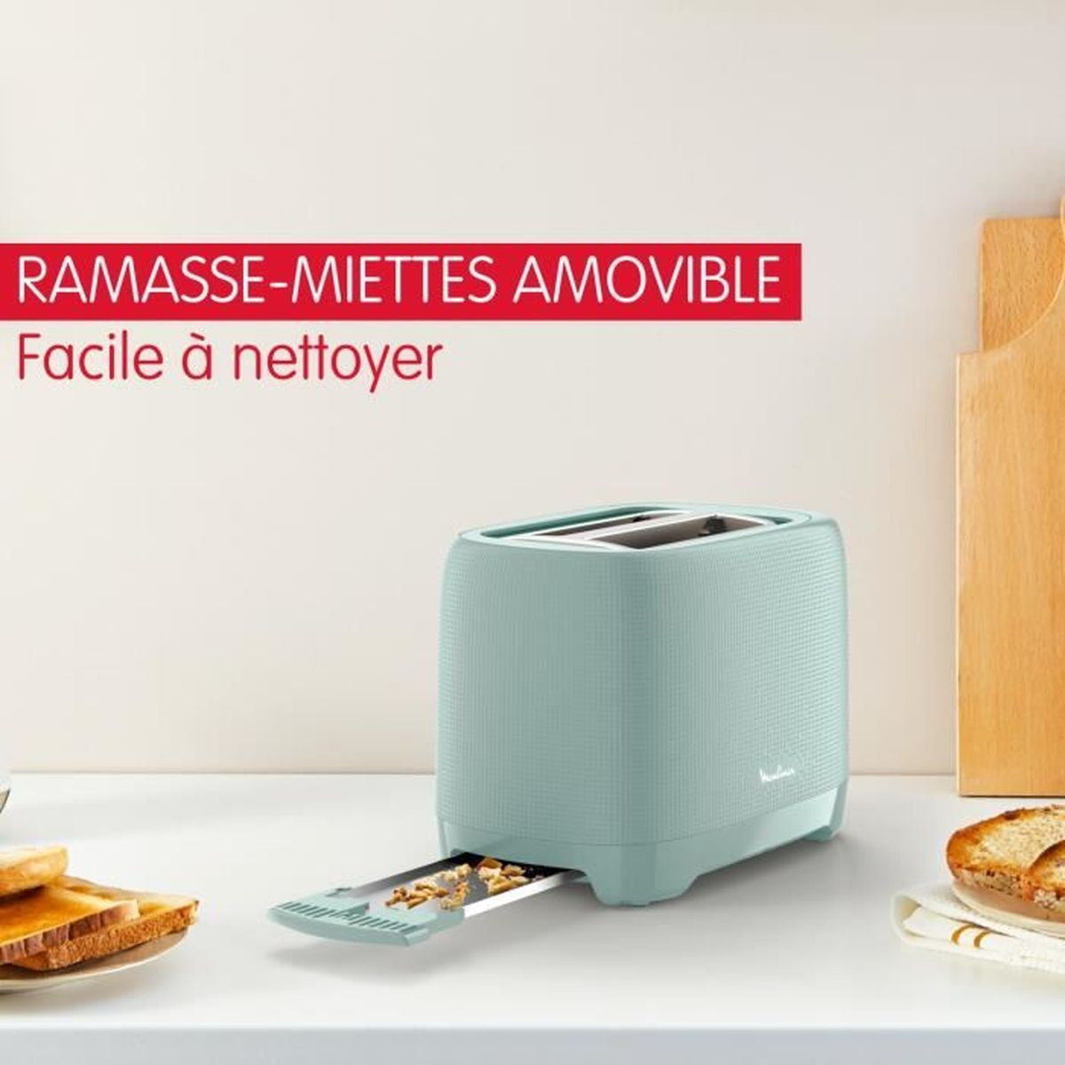 Blauer Toaster mit herausnehmbarer Krümelschublade auf weißer Arbeitsplatte. Brot toastet.