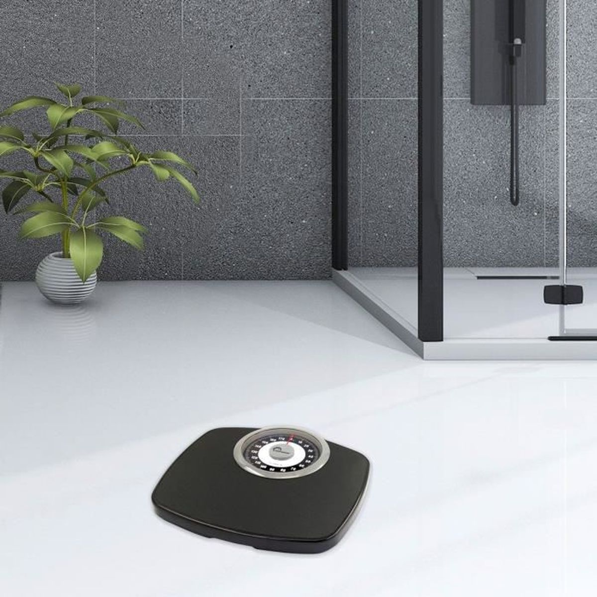 Czarna kwadratowa waga z okrągłą tarczą na białej podłodze. Zielona roślina w doniczce i prysznic w tle.