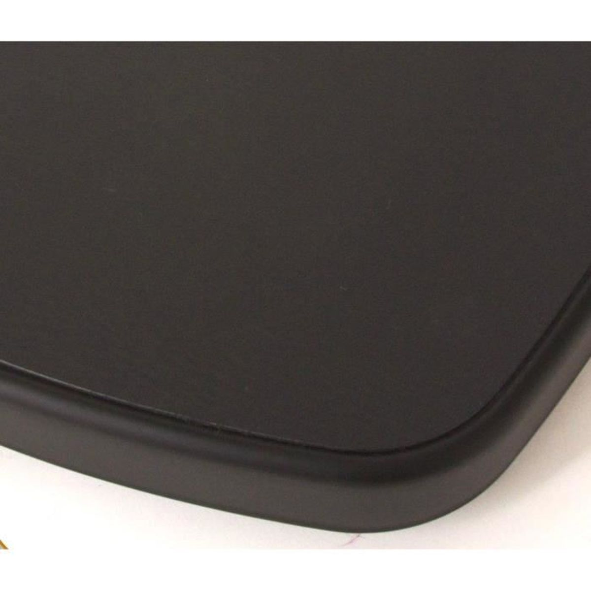 Zbliżenie czarnego, kwadratowego obiektu z zaokrąglonymi krawędziami.