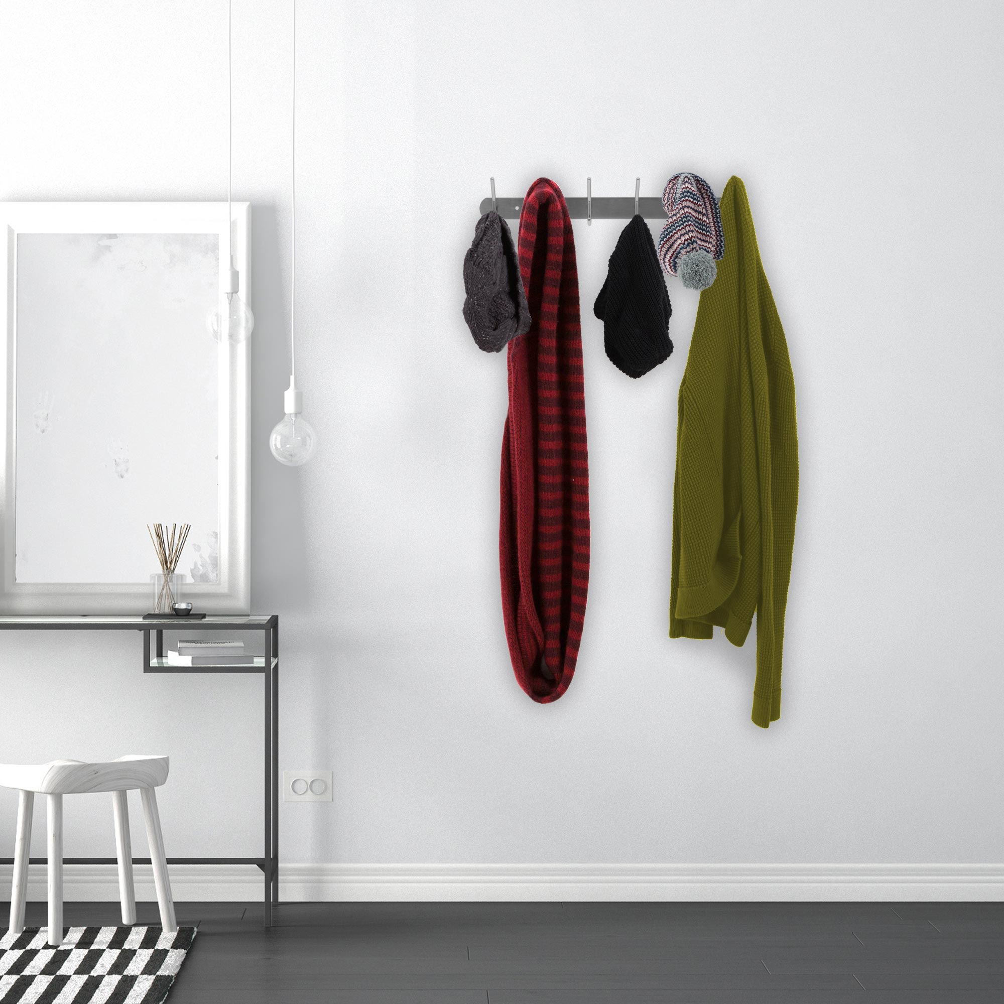 Wand mit Kleiderständer. Hüte, Schals und eine Jacke hängen. Spiegel und Hocker links.