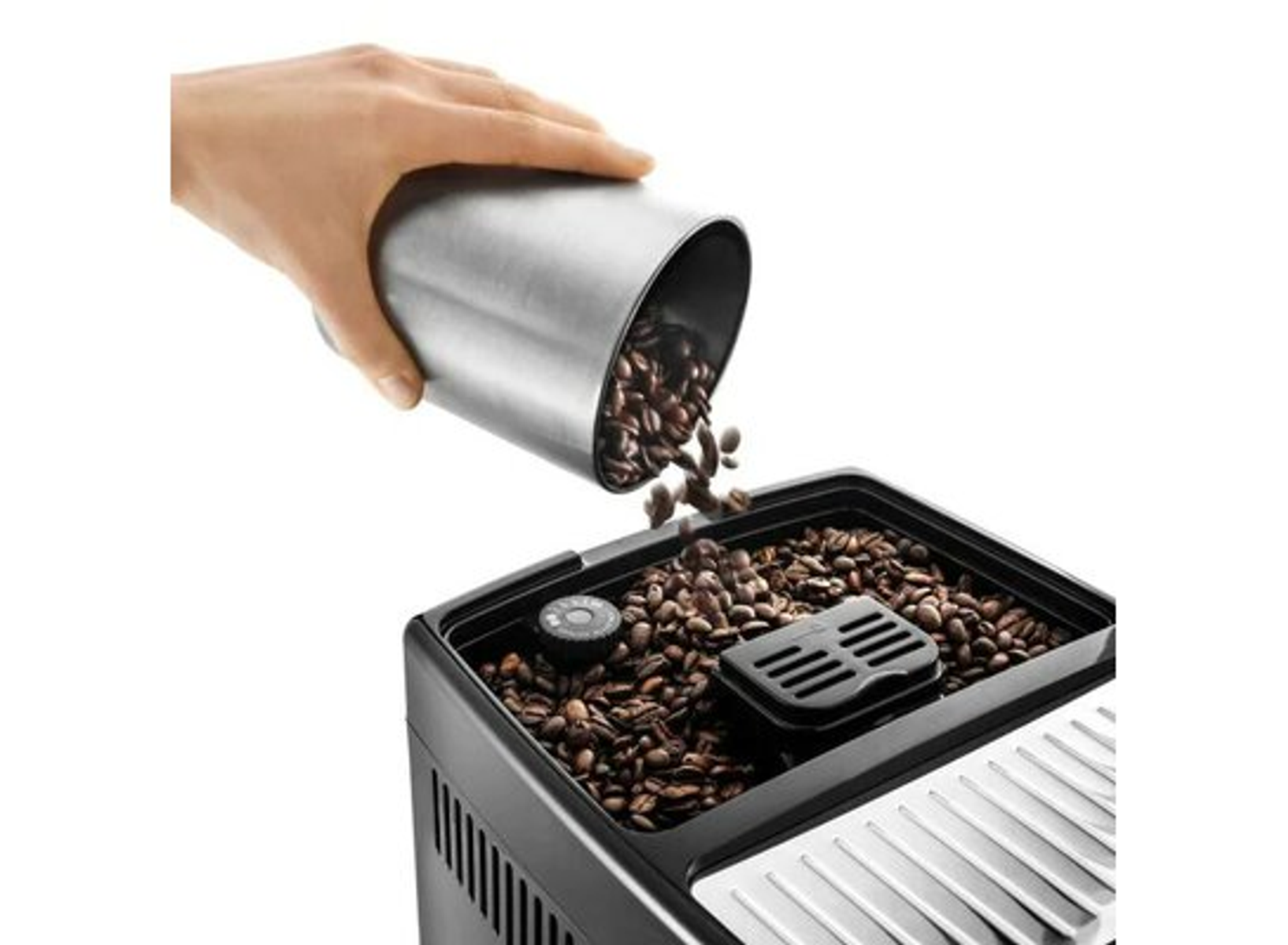 Hand gießt Kaffeebohnen in eine schwarze Kaffeemaschine, Nahaufnahme.