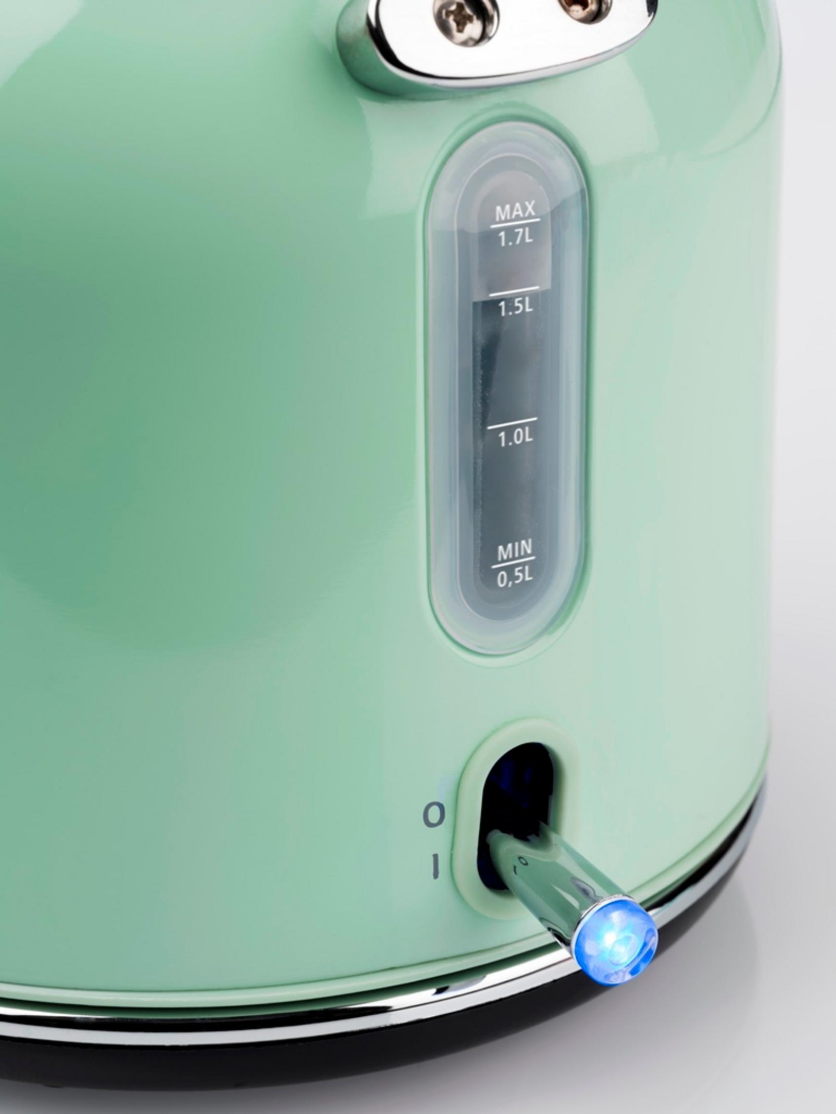 Grüner Wasserkocher mit blauem Licht. Er hat eine Wasserstandsanzeige. Auf weißem Hintergrund.