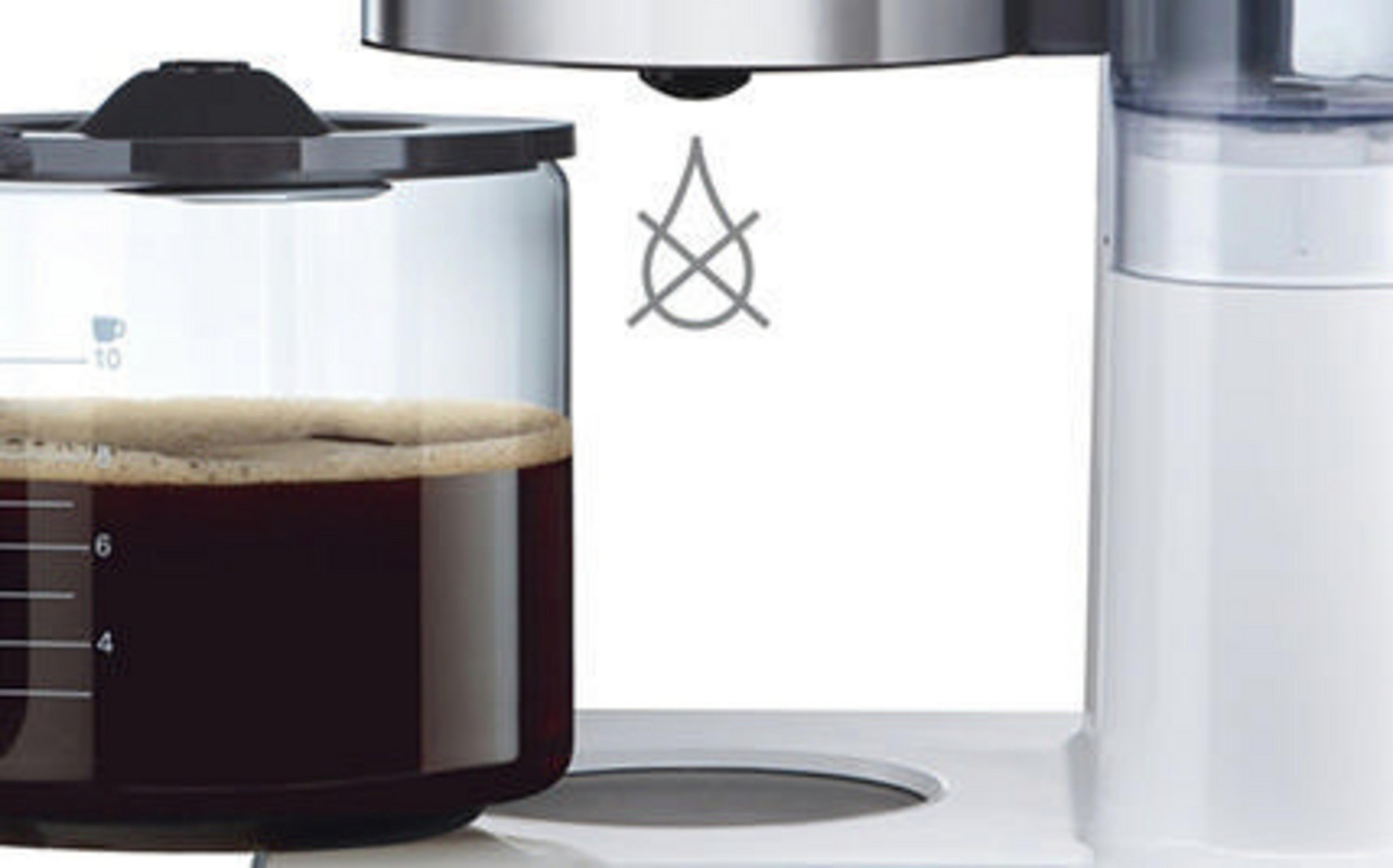 Zbliżenie ekspresu do kawy, pokazujące szklany dzbanek wypełniony kawą i symbol anty-kapania.