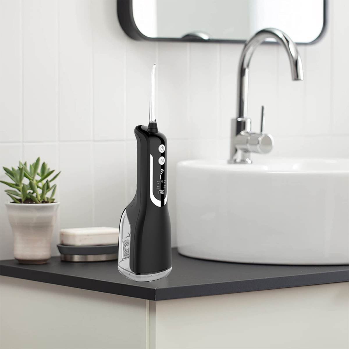 Schwarzer Wasserflosser auf schwarzer Oberfläche. Weißes Waschbecken und Hintergrund.
